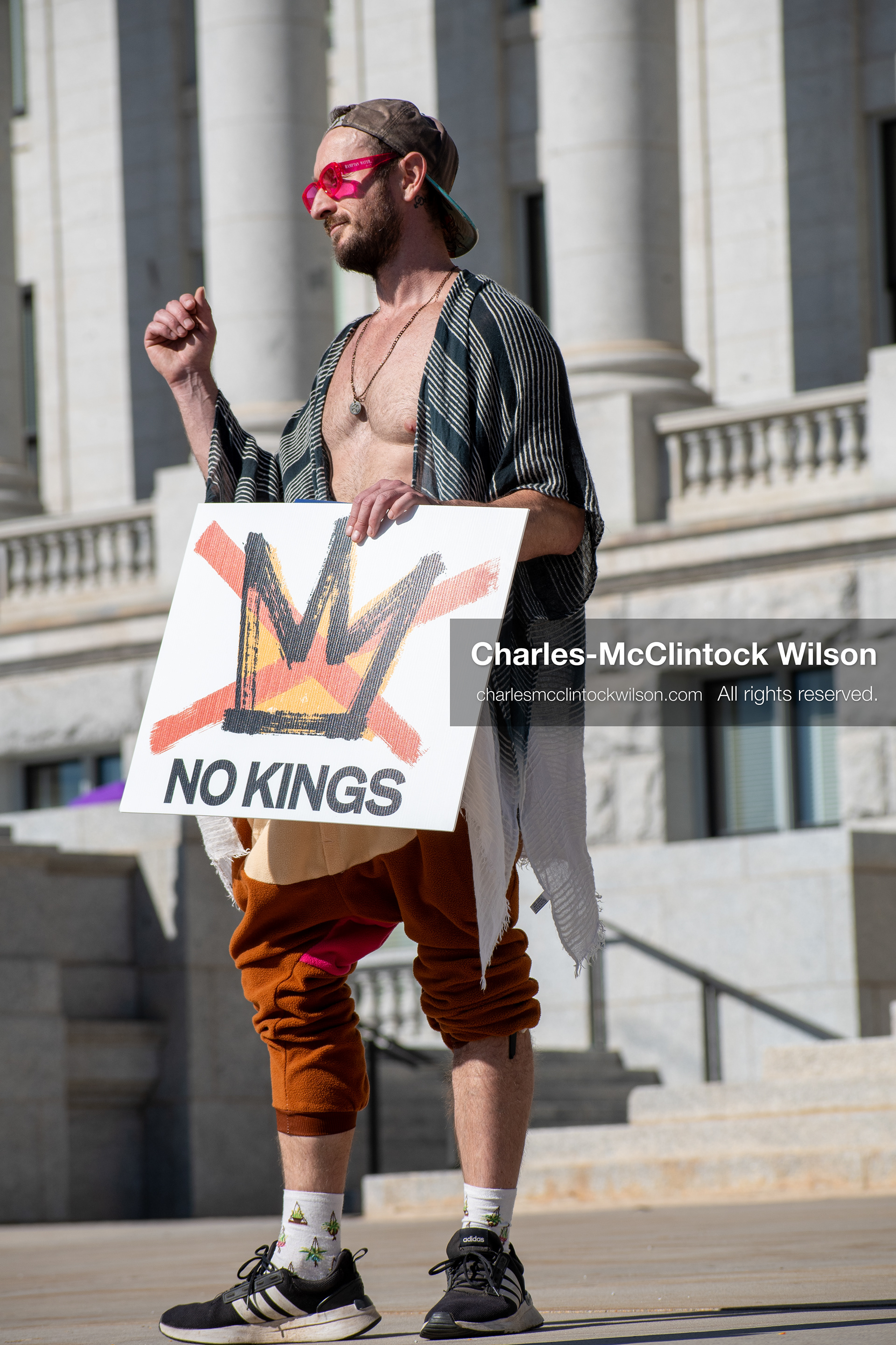 October 18, 2025, Salt Lake City, Utah, USA: A demonstrator holds a sign featuring a crossed-out crown and the phrase "No Kings" during a protest outside a government building in Salt Lake City, Utah. The protest was part of a nationwide mobilization.