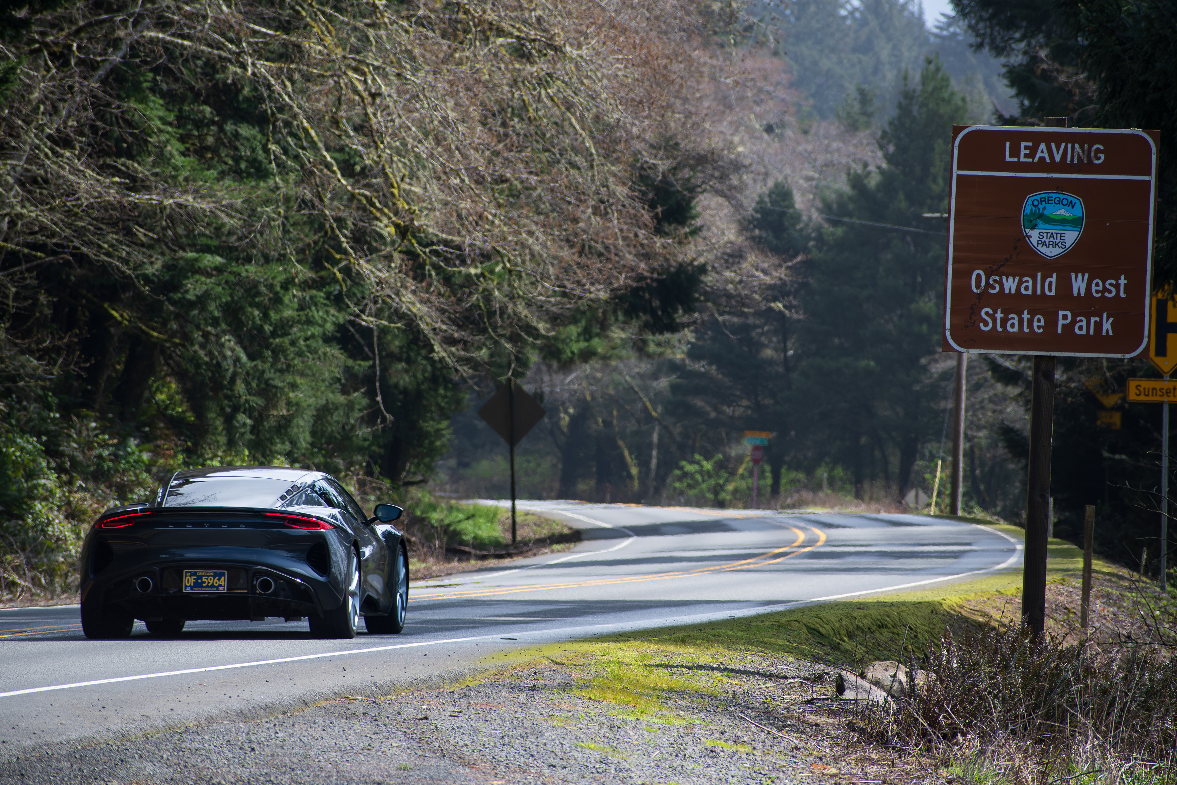 TILLAMOOK, OR, USA - APR 12, 2025: A single car travels along U.S. Route 101 through Tillamook, surrounded by the stunning natural beauty of Oregon's coastal landscape.