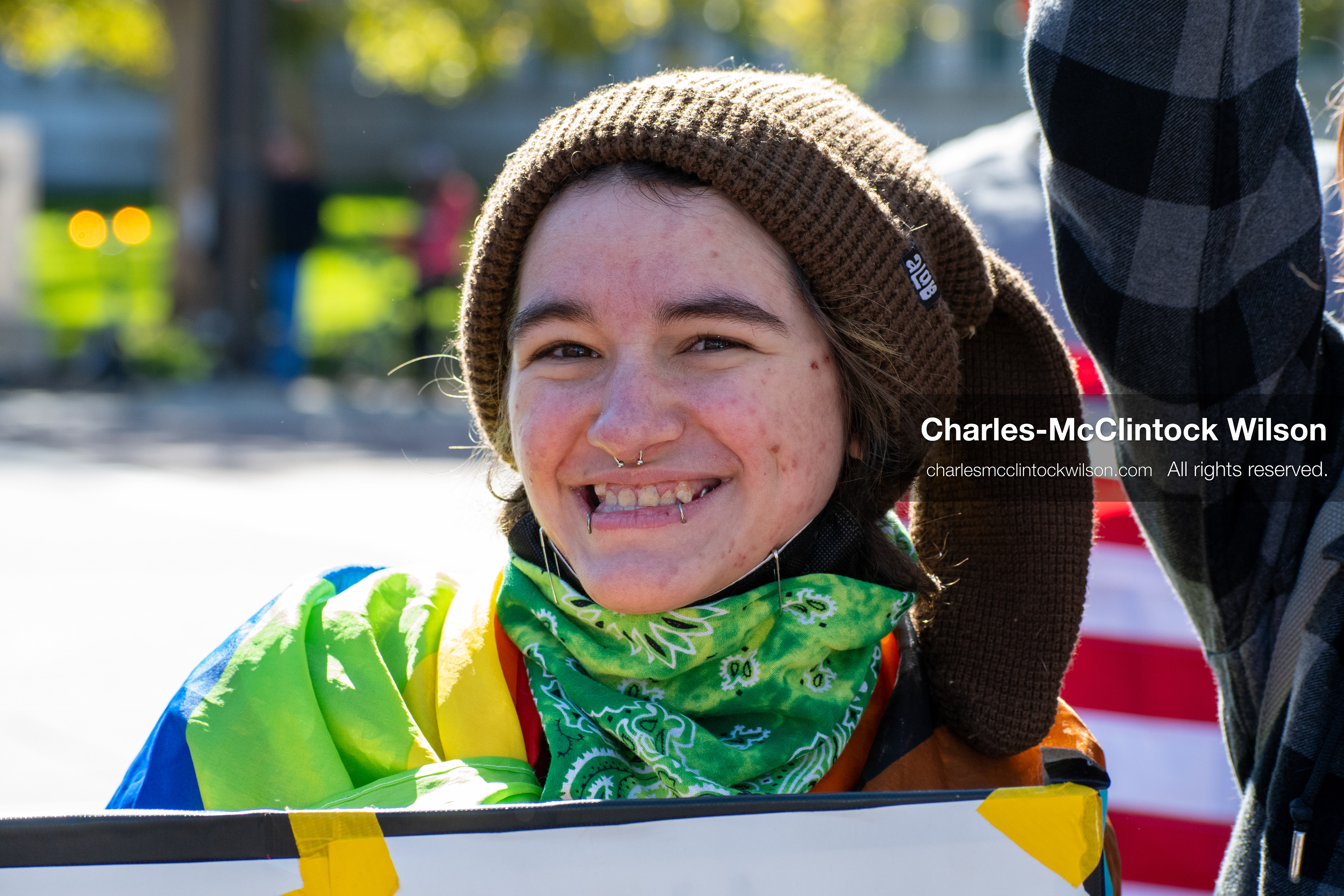 Salt Lake City, Utah, U.S., October 18, 2025: A demonstrator smiles while holding a sign during a “No Kings” protest at the Utah State Capitol. The nationwide movement, organized in opposition to U.S. President Donald Trump’s administration, drew thousands to the Capitol lawn in a show of peaceful resistance and civic choreography.