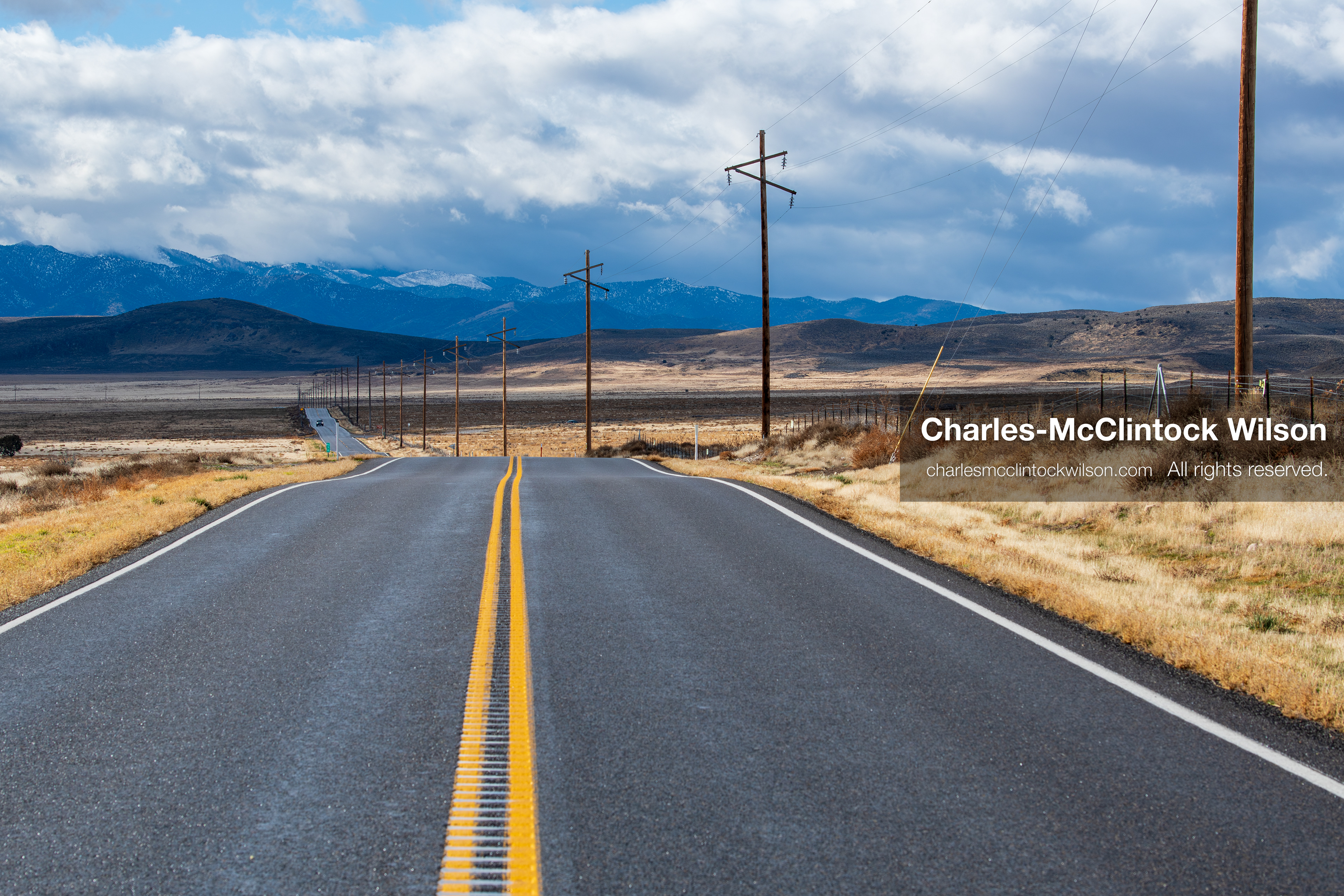 January 1, 2026, Saratoga Springs, Utah, USA: A rural road stretches toward distant mountains on January 1, 2026, near Saratoga Springs, Utah, USA. Utility poles line the route as dry grass and open plains frame the landscape under partly cloudy skies. (Credit Image: © Charles-McClintock Wilson/ZUMA Press Wire)
