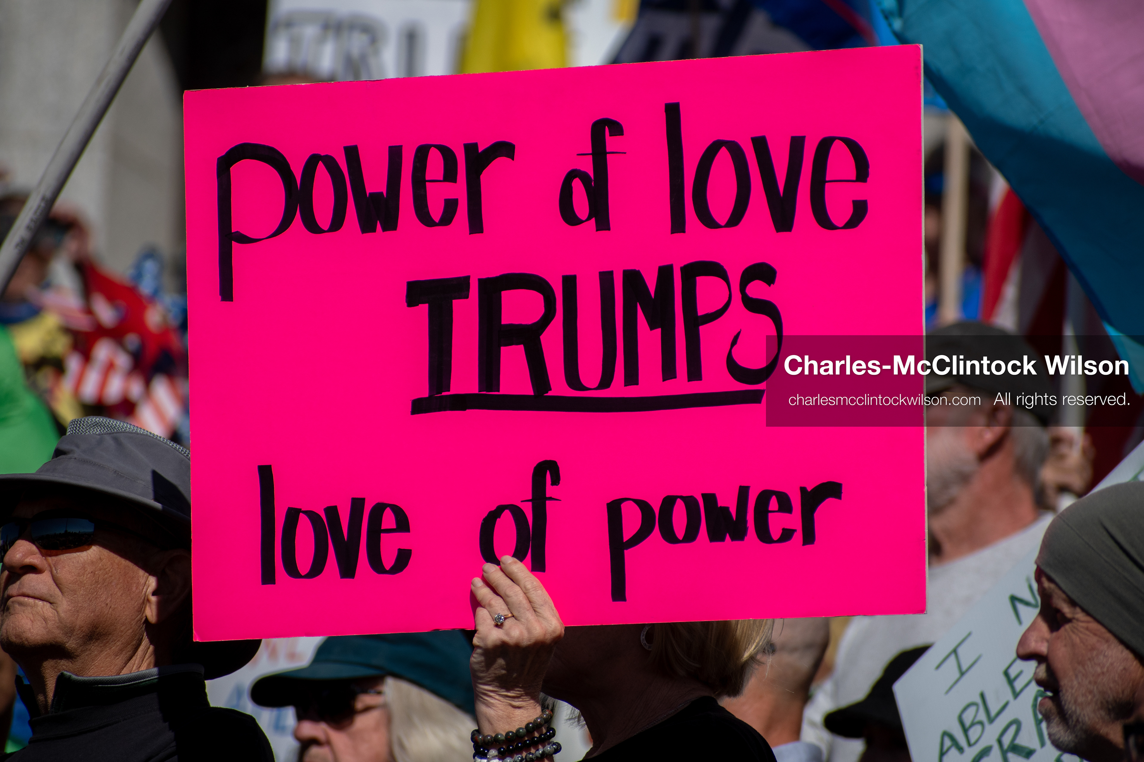 October 18, 2025, Salt Lake City, Utah, USA: A demonstrator raises a placard during a "No Kings" protest held at the Utah State Capitol. Other participants and signs are visible in the background during the public gathering.