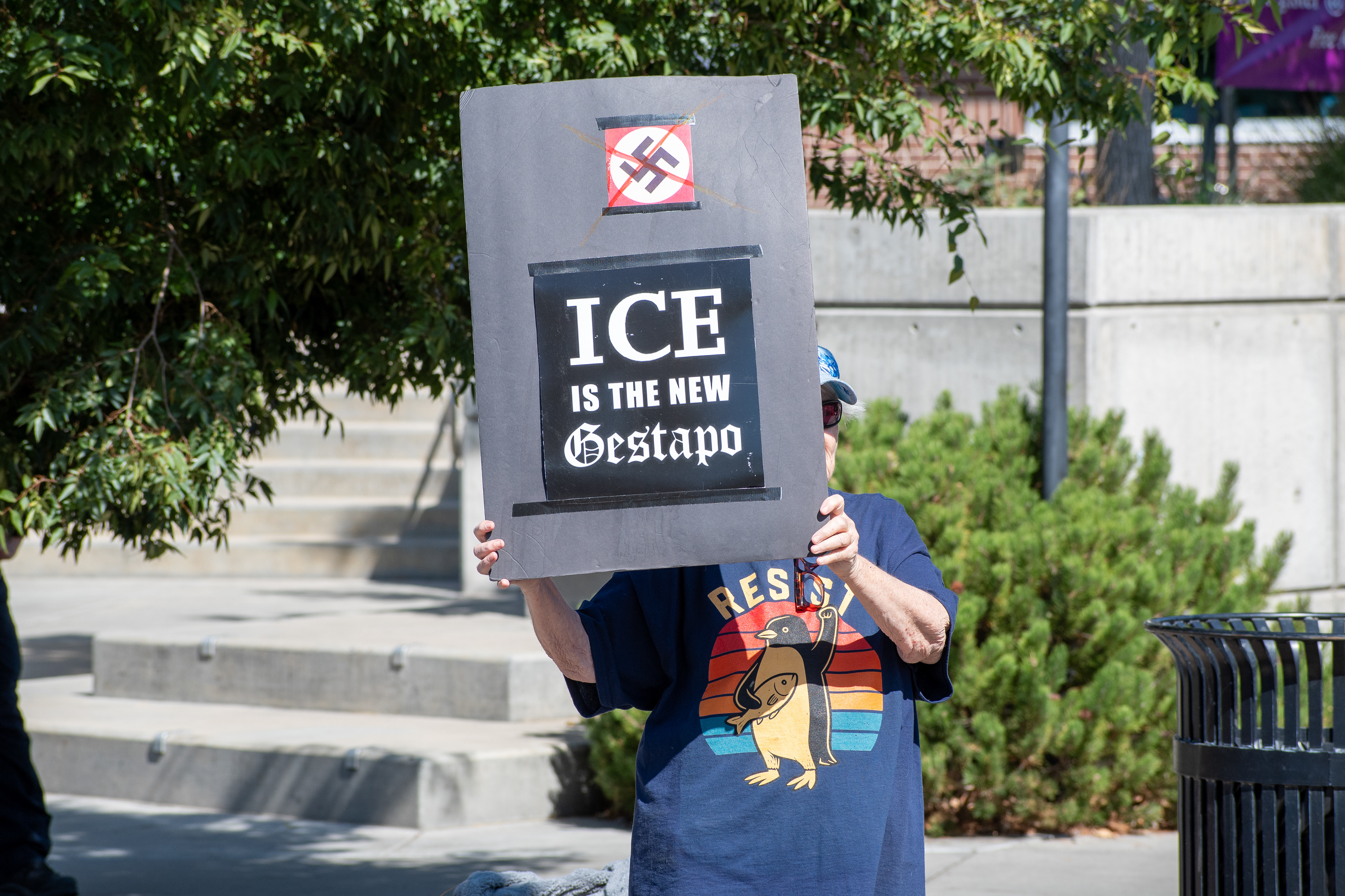 September 15, 2025 – Provo, Utah, United States: A demonstrator holds a sign reading “ICE IS THE NEW Gestapo” with a crossed-out swastika graphic outside the Utah Valley Convention Center during a protest against the Department of Homeland Security career expo. The individual’s shirt features the word “RESIST” and a phoenix rising from flames, symbolizing defiance and renewal. Photograph by Charles‑McClintock Wilson / ZUMA Press Wire