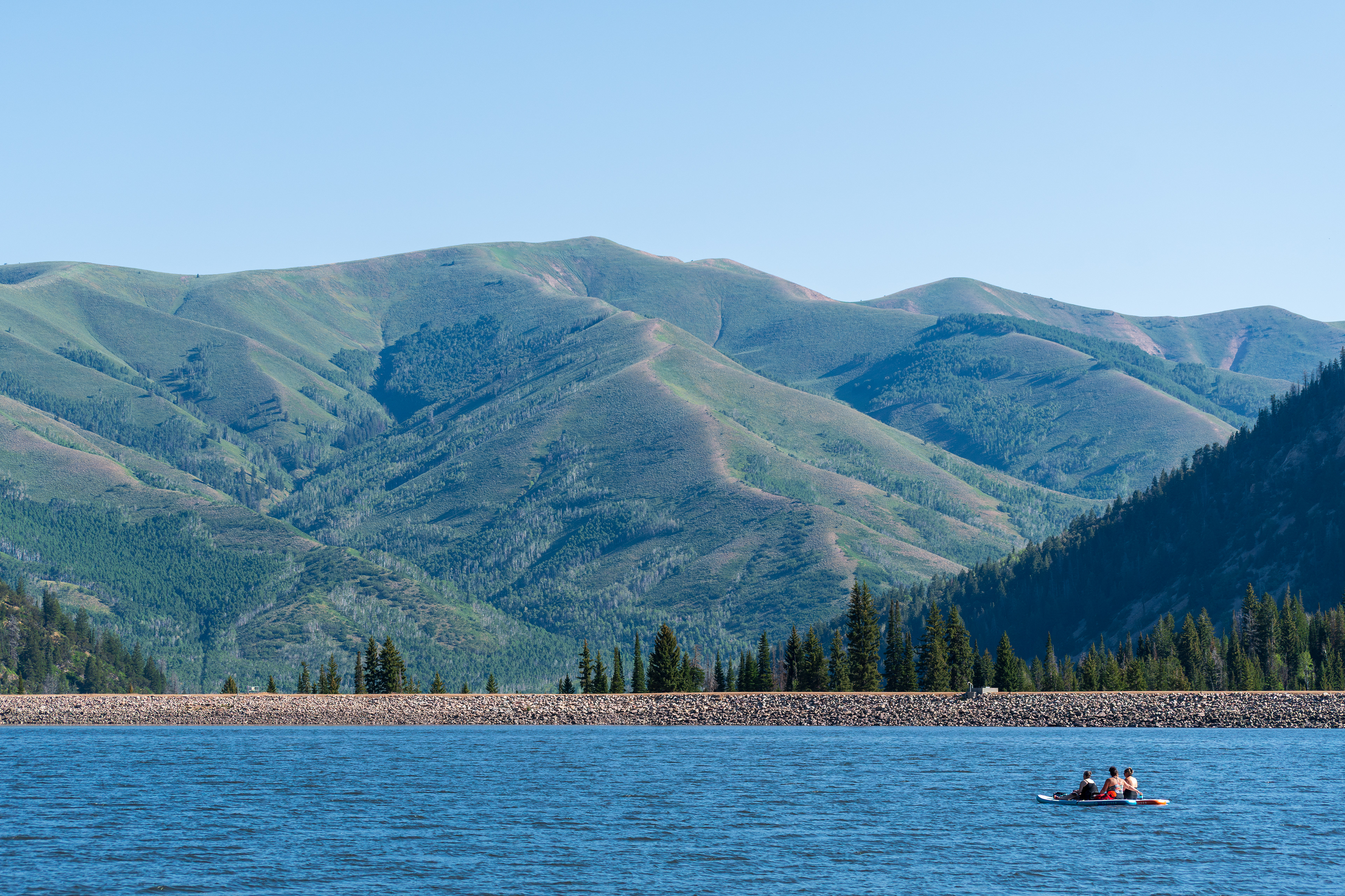 Summit County, Utah – July 20, 2025: People paddleboard across the calm waters of Smith and Morehouse Reservoir during a summer outing.