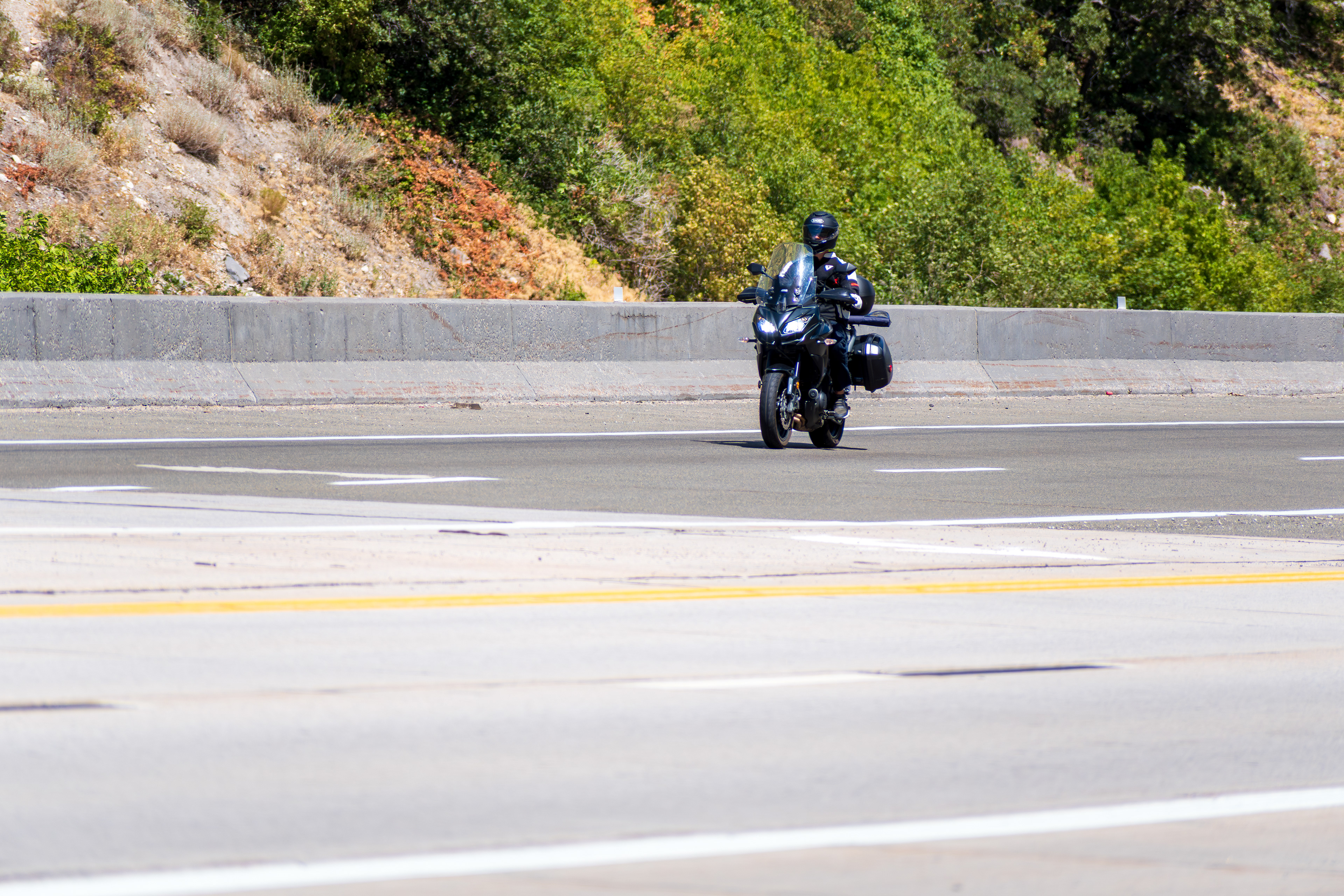 Provo Canyon, Utah, USA — September 1, 2025: A motorcyclist travels northbound along U.S. Route 189, framed by canyon foliage and roadside infrastructure.