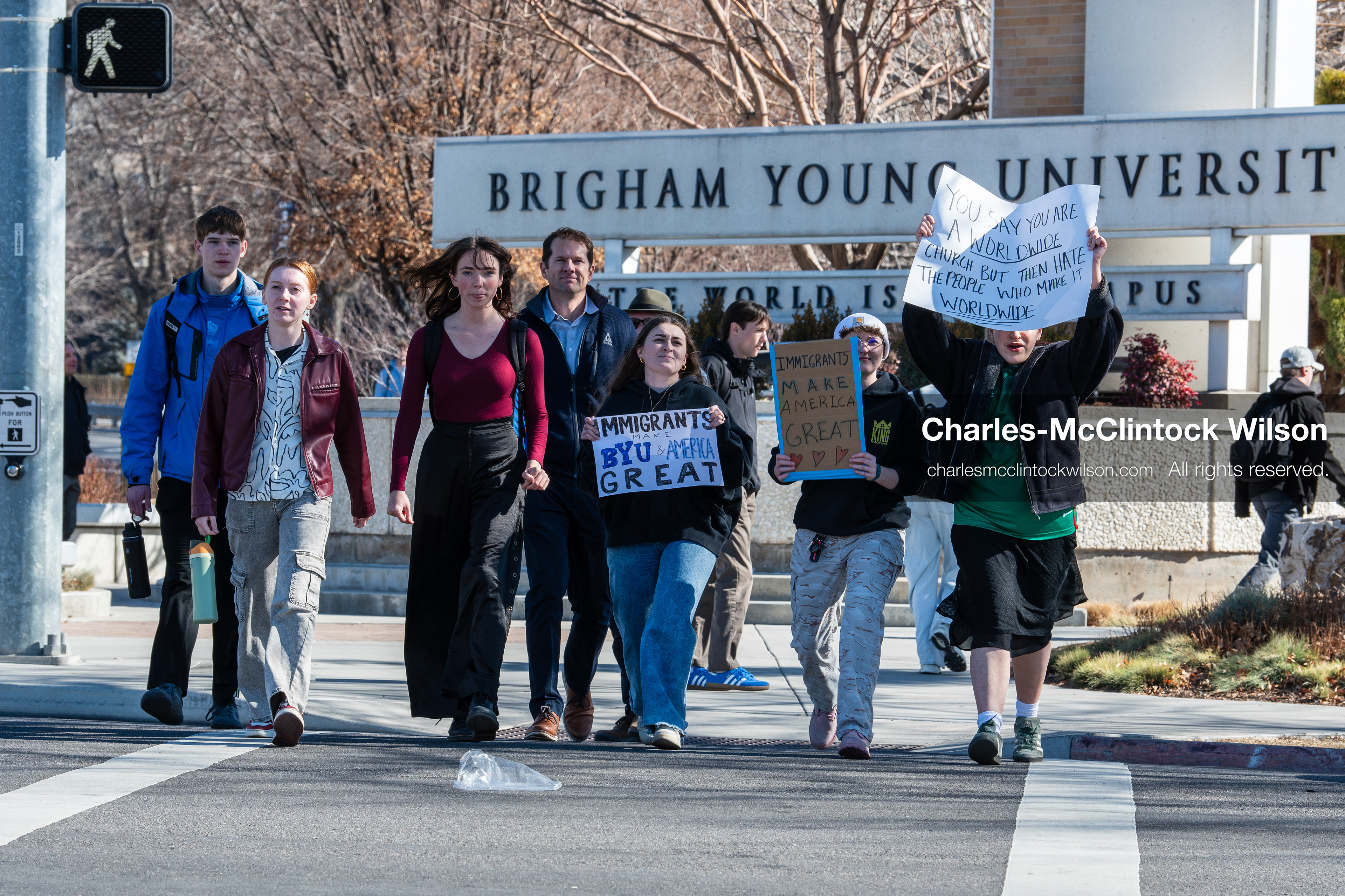 February 5, 2026, Provo, Utah, USA: People walk near the Brigham Young University entrance in Provo as demonstrators carrying signs gather to protest the presence of US Customs and Border Protection recruiters at a career fair held on the BYU campus. (Credit Image: © Charles McClintock Wilson/ZUMA Press Wire)