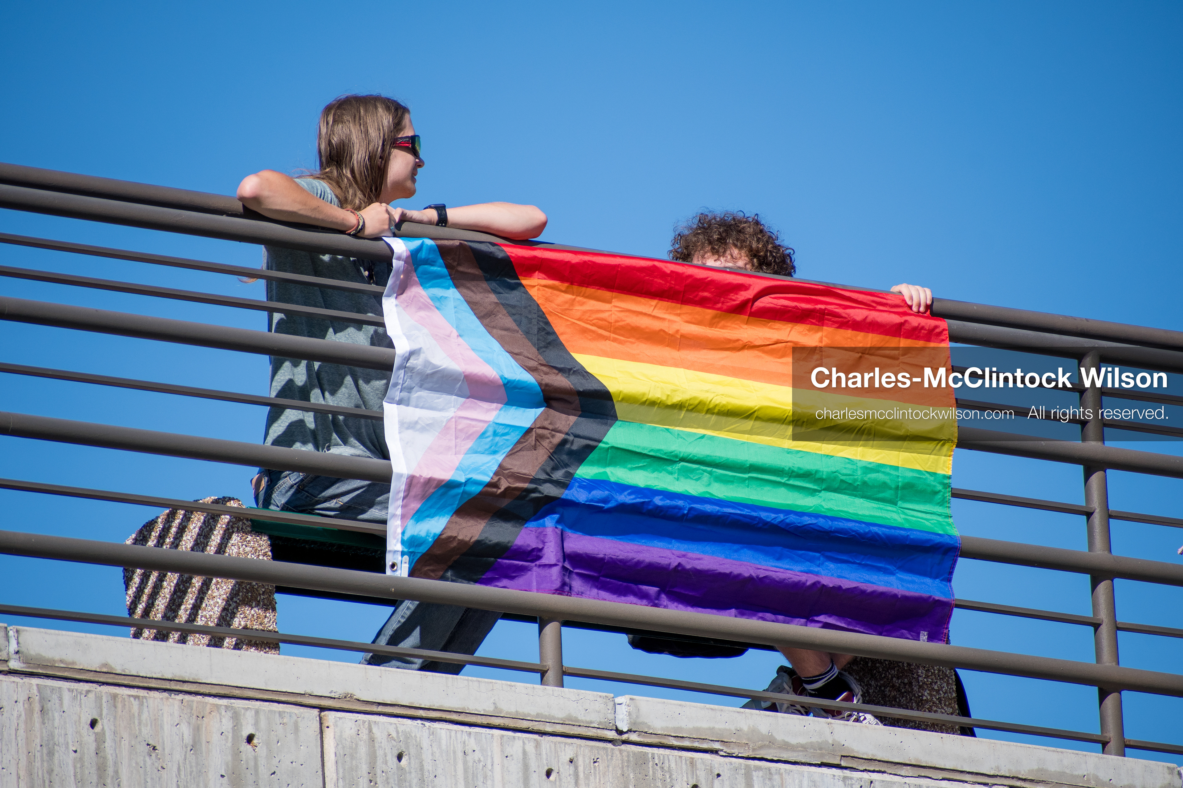 September 10, 2025, Orem, Utah, USA: A group of individuals stand atop the Fountain Courtyard at Utah Valley University, holding a Progress Pride flag during conservative activist Charlie Kirk’s American Comeback Tour appearance. The event drew over 3,000 attendees and was marked by heightened civic tension and symbolic gestures from both supporters and critics. Kirk was fatally shot moments later during the public Q&A session, prompting national scrutiny of campus security protocols and institutional response. (Credit Image: © Charles‑McClintock Wilson/ZUMA Press Wire)