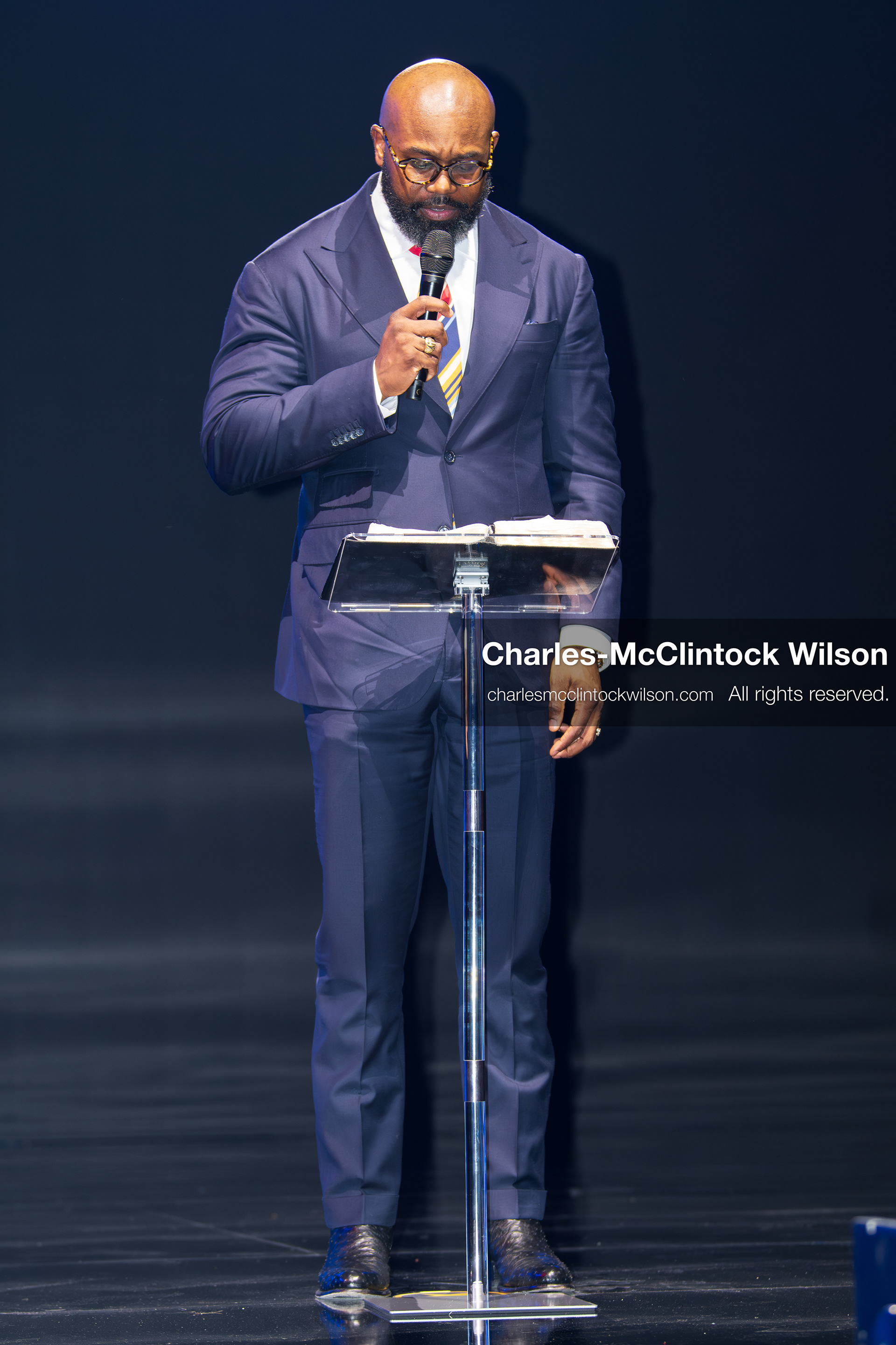 December 18, 2025, Phoenix, Arizona, USA: Pastor John Amanchukwu speaks on stage during AmericaFest 2025 at the Phoenix Convention Center, holding a microphone behind a transparent podium. (Credit Image: (c) Charles-McClintock Wilson/ZUMA Press Wire)