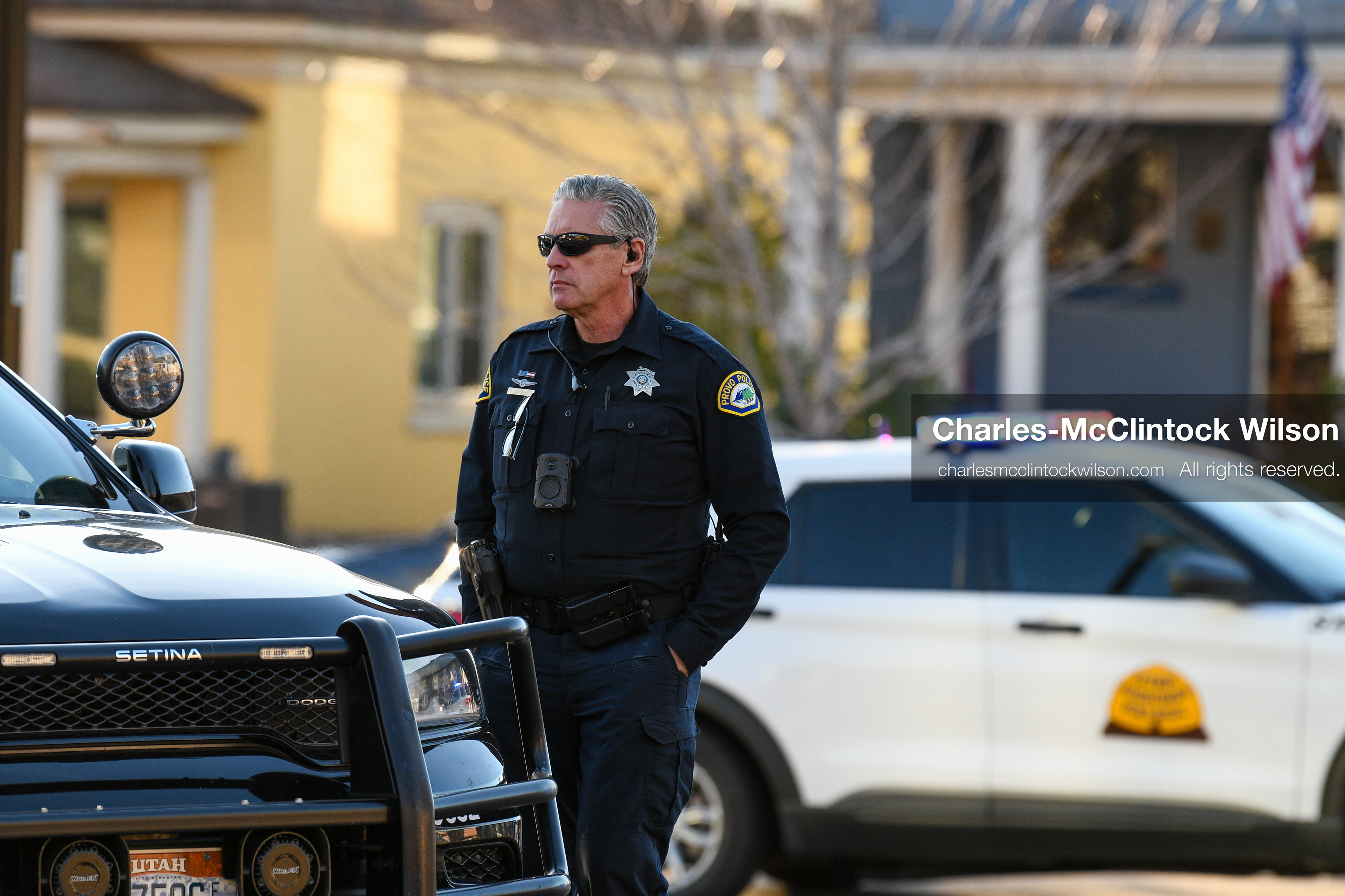 PROVO, UTAH, USA – DECEMBER 11, 2025: A Provo Police officer stands beside a patrol vehicle in a residential neighborhood near the Fourth District Court in Provo during the first in‑person court appearance of Tyler Robinson in the Charlie Kirk murder case. (Credit Image: © Charles‑McClintock Wilson/ZUMA Press Wire)