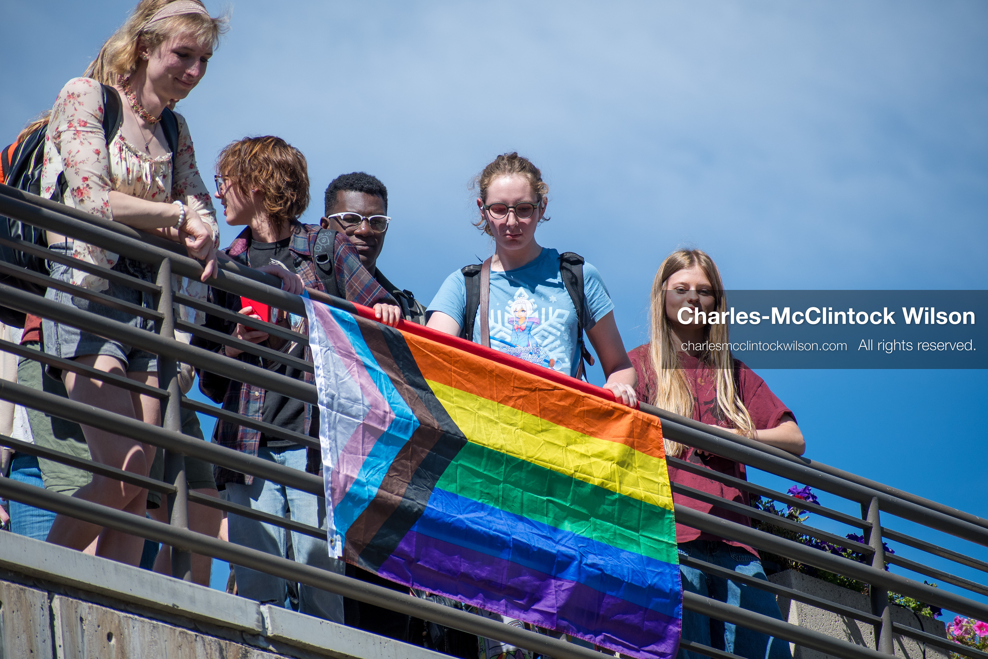 September 10, 2025, Orem, Utah, USA: A group of individuals stand atop the Fountain Courtyard at Utah Valley University, holding a Progress Pride flag during conservative activist Charlie Kirk’s American Comeback Tour appearance. The event drew over 3,000 attendees and was marked by heightened civic tension and symbolic gestures from both supporters and critics. Kirk was fatally shot moments later during the public Q&A session, prompting national scrutiny of campus security protocols and institutional response. (Credit Image: © Charles‑McClintock Wilson/ZUMA Press Wire)