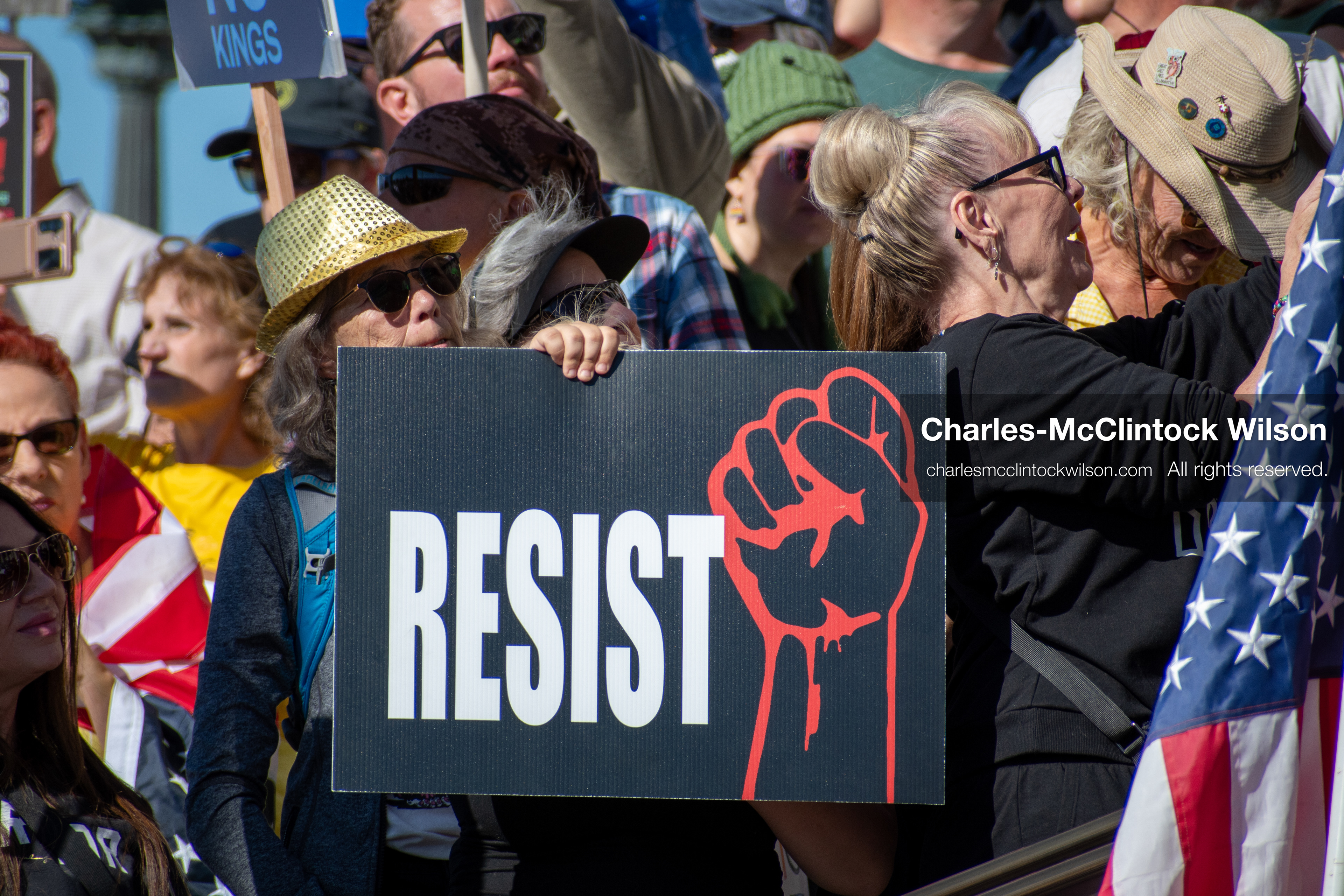 October 18, 2025, Salt Lake City, Utah, USA: A demonstrator raises a placard during a "No Kings" protest held at the Utah State Capitol. Other participants and signs are visible in the background during the public gathering.