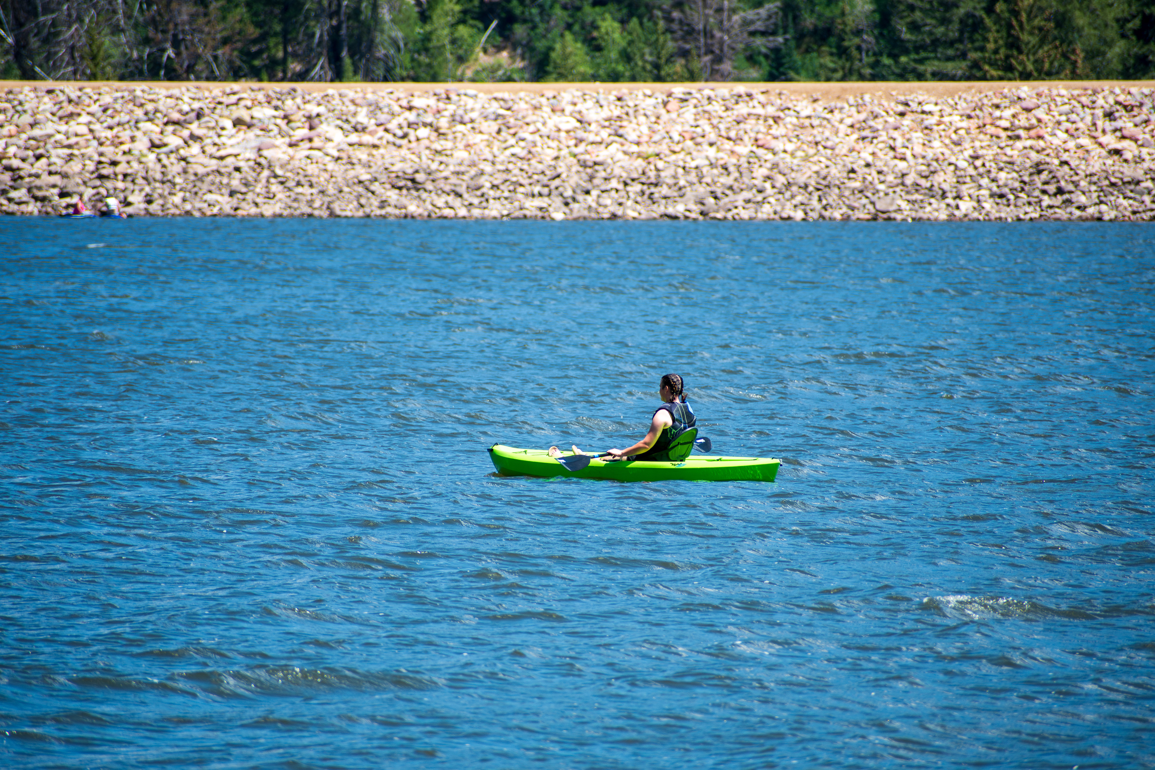 Summit County, Utah – July 20, 2025: A woman paddles a kayak across the calm waters of Smith and Morehouse Reservoir during a peaceful summer outing.