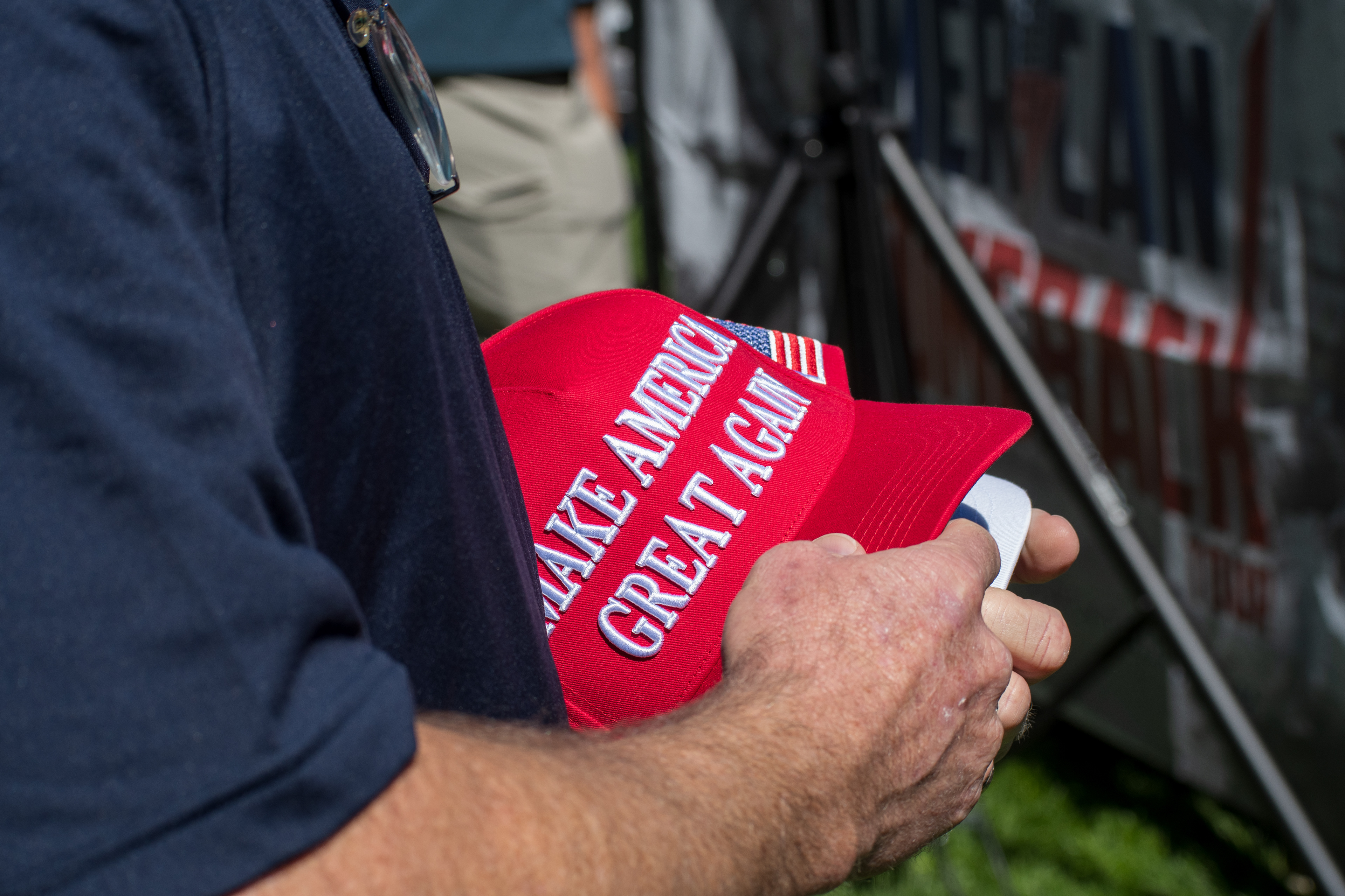 OREM, UTAH – SEPTEMBER 10, 2025: An event staffer organizes merchandise ahead of Charlie Kirk’s scheduled appearance at Utah Valley University. Holding a stack of red and white caps, the individual reflects the logistical coordination and quiet preparation that shaped the opening stop of the American Comeback Tour. The image captures a moment of order, presence, and behind-the-scenes engagement. © Charles-McClintock Wilson / ZUMA Press