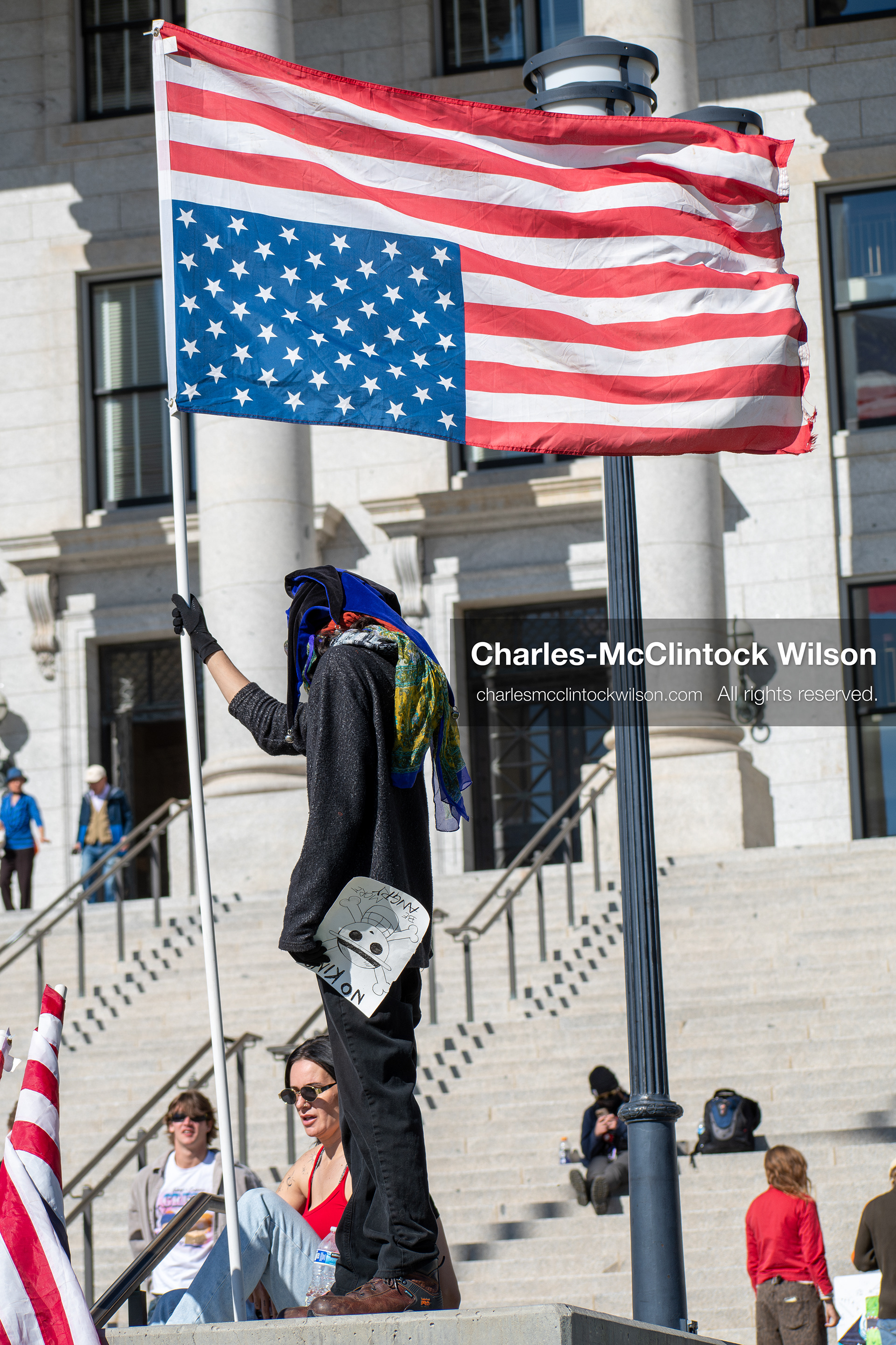 October 18, 2025, Salt Lake City, Utah, USA: A demonstrator stands with an altered American flag during a "No Kings" protest at the Utah State Capitol in Salt Lake City, Utah. The protest was part of a nationwide mobilization.