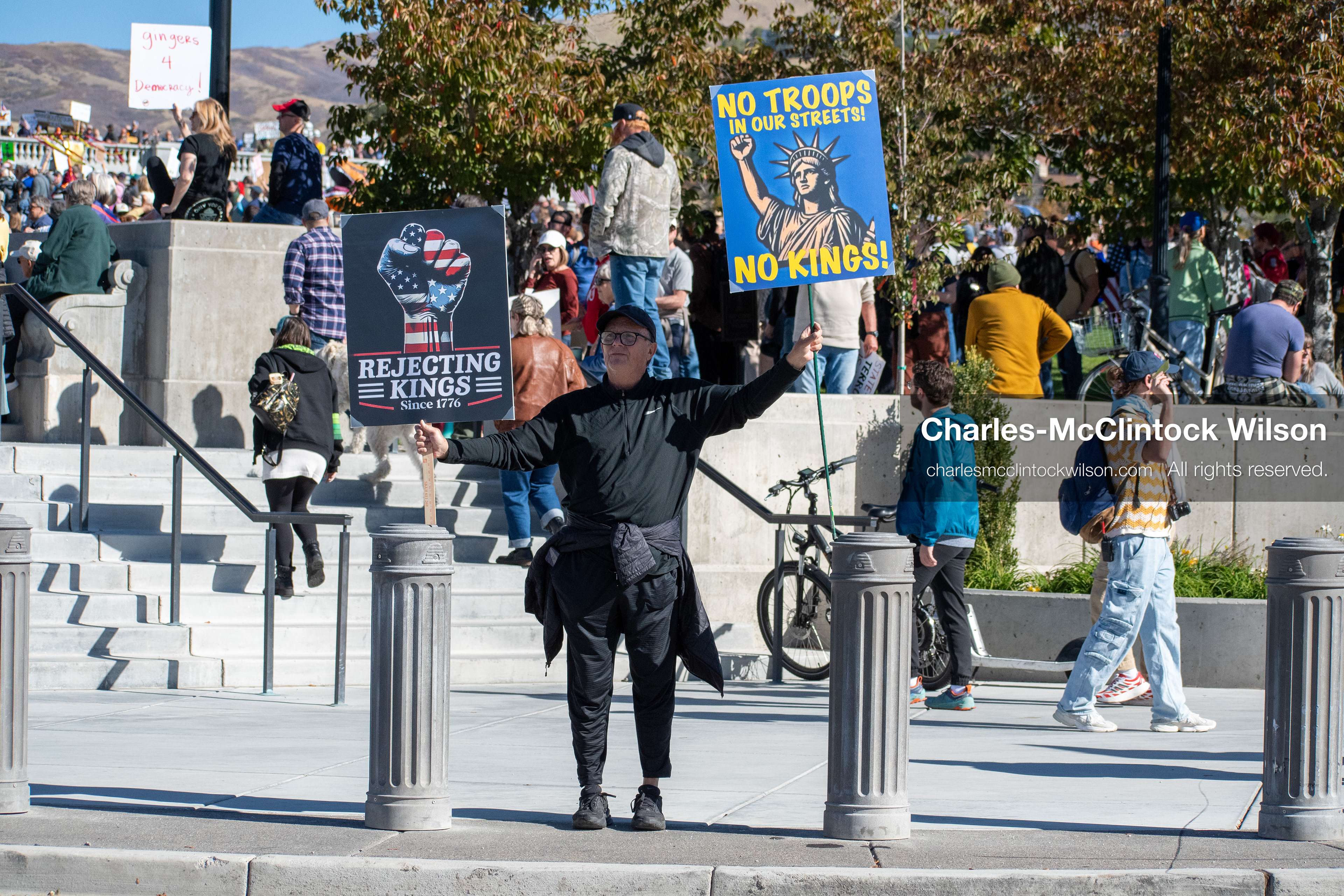 October 18, 2025, Salt Lake City, Utah, USA: A demonstrator holds signs during a "No Kings" protest at the Utah State Capitol. The protest was part of a nationwide mobilization.