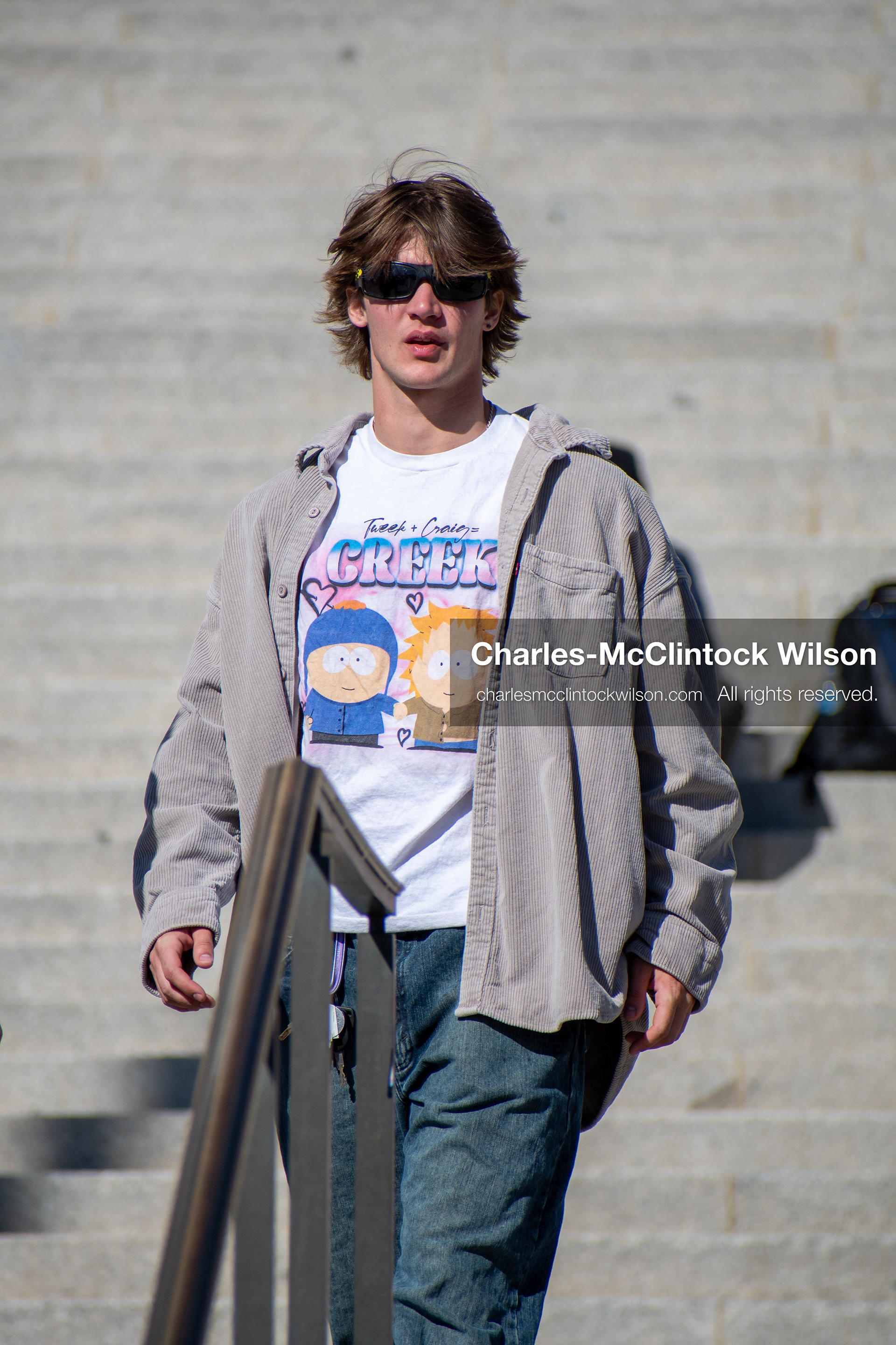 Salt Lake City, Utah, U.S., October 18, 2025: A demonstrator wearing sunglasses and a light jacket walks the steps of the Utah State Capitol during a “No Kings” protest. The demonstration, organized in opposition to U.S. President Donald Trump’s administration, called for restraint in executive power and rejected personality-driven governance.