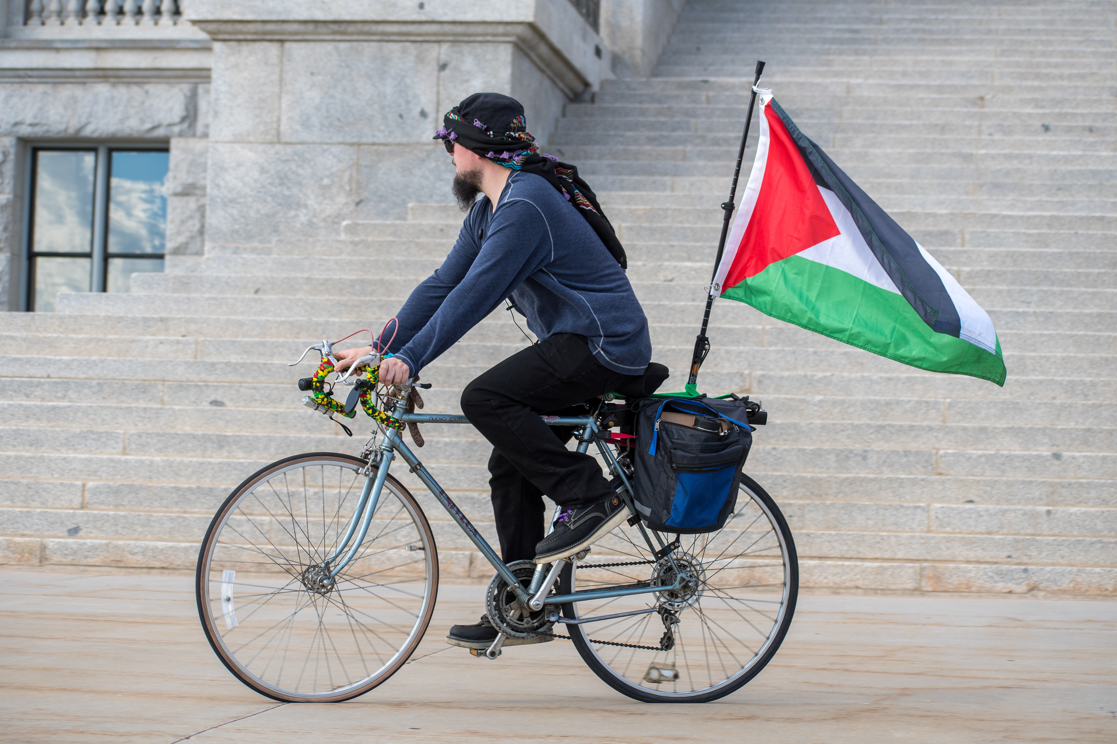 October 10, 2025, Salt Lake City, Utah, USA: A demonstrator rides past the Utah State Capitol during the Free Palestine Rally. A Palestinian flag is mounted to the bicycle. (Credit Image: © Charles-McClintock Wilson/ZUMA Press Wire)
