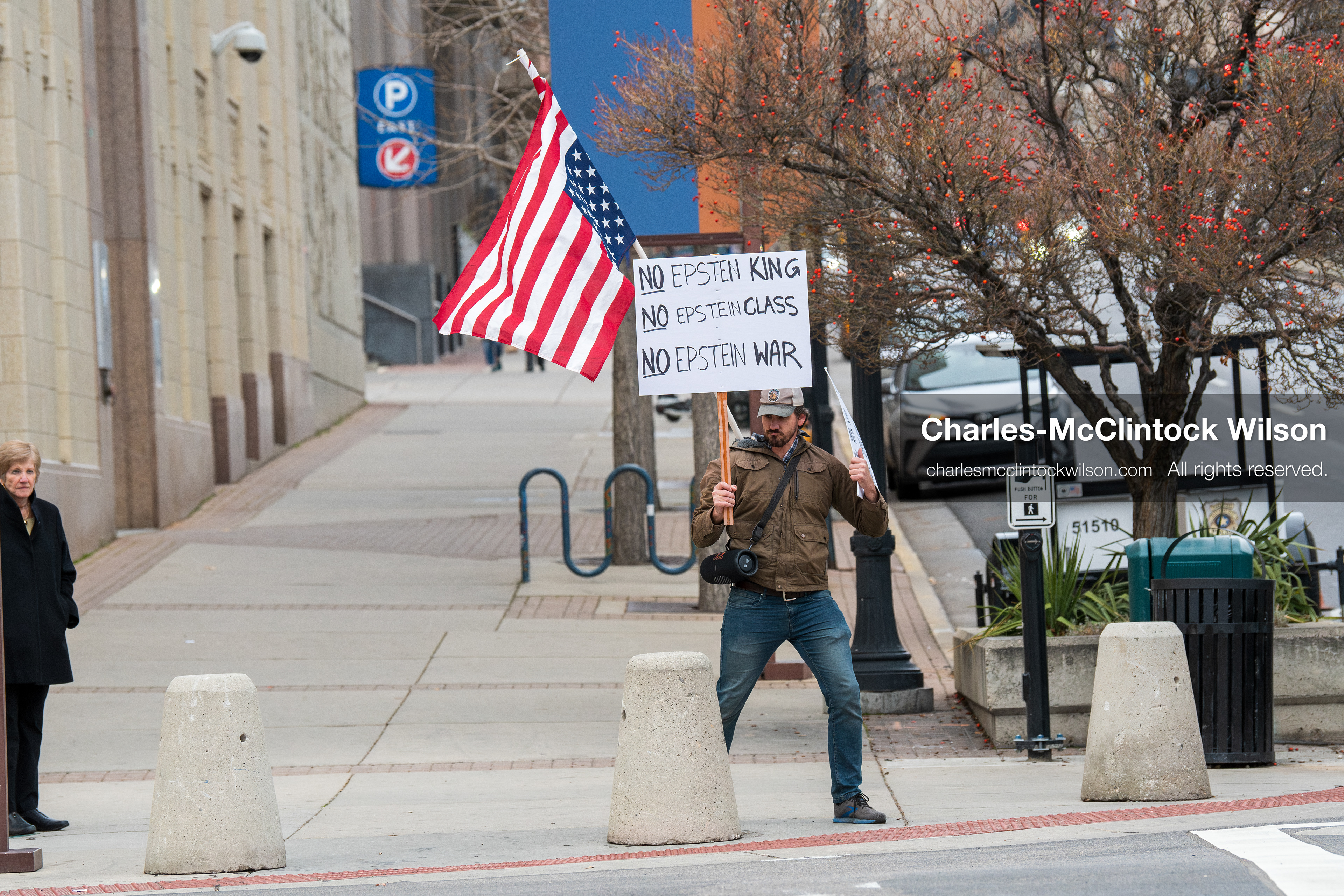 January 3, 2026, Salt Lake City, Utah, USA: A protester holds signs and an American flag during a demonstration against US action in Venezuela outside the Wallace Federal Building in Salt Lake City, Utah. The protest was part of a nationwide mobilization responding to recent military developments. (Credit Image: (c) Charles‑McClintock Wilson/ZUMA Press Wire)