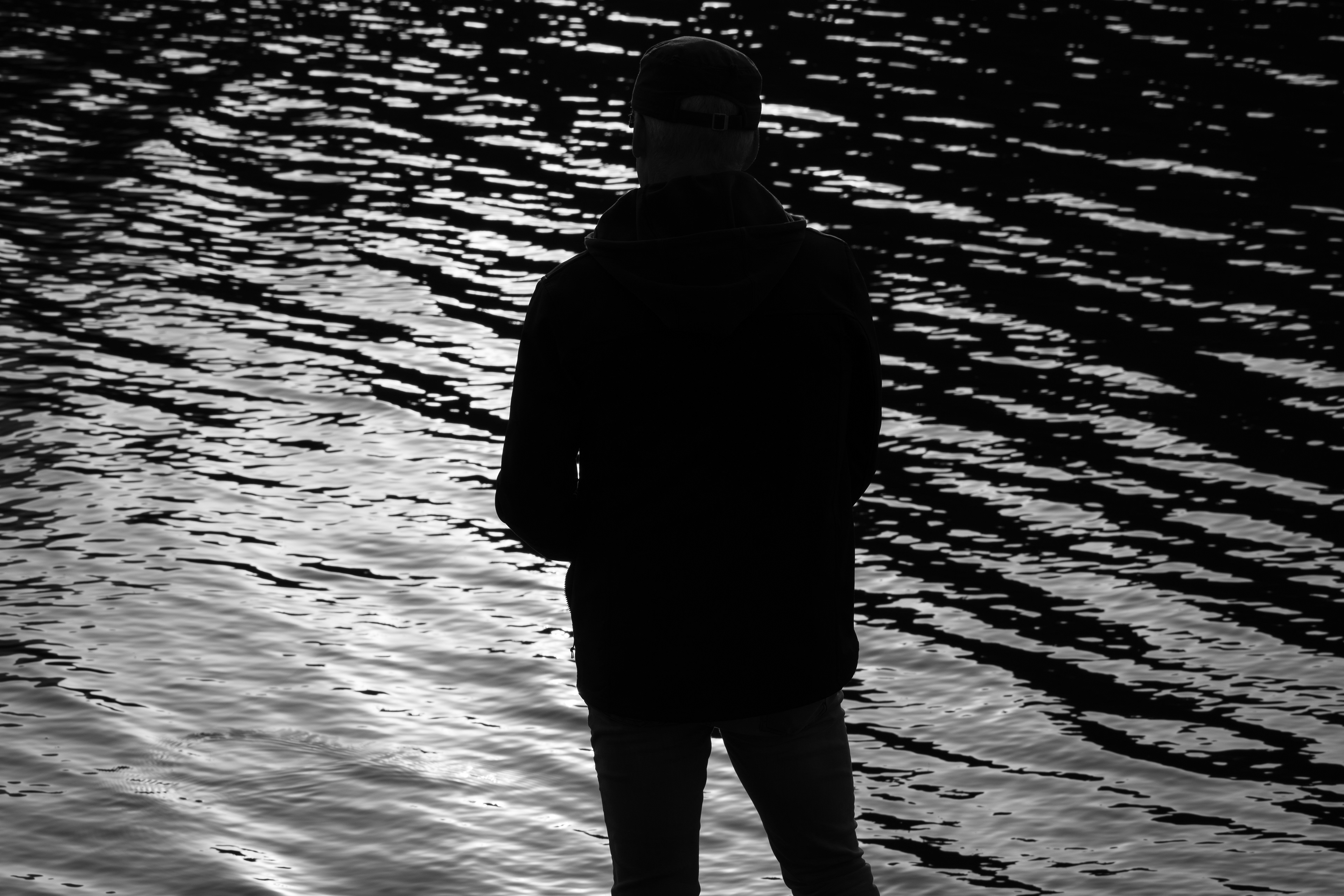 Summit County, Utah – July 20, 2025: A black and white image of a man fishing captures a quiet moment at Smith and Morehouse Reservoir.