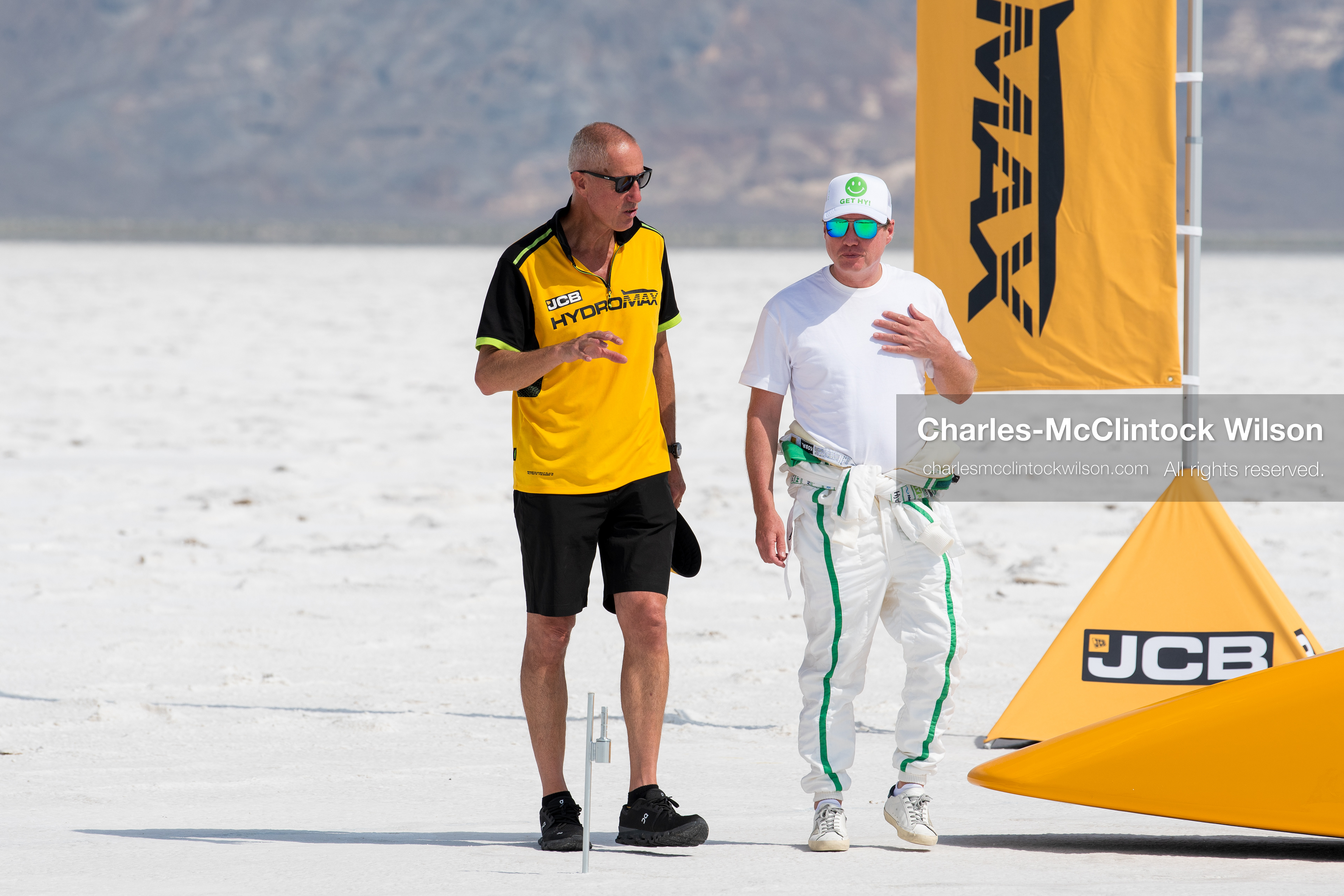 August 11, 2026, Wendover, Utah, USA: British pilot ANDY GREEN, wearing a yellow and black JCB polo shirt, walks alongside a team technician across the Bonneville Salt Flats on Tuesday. Green piloted the hydrogen-powered ''JCB Hydromax'' streamliner to a historic record-breaking top speed of 406.320 mph. (Credit Image: © Charles McClintock Wilson/ZUMA Press Wire)