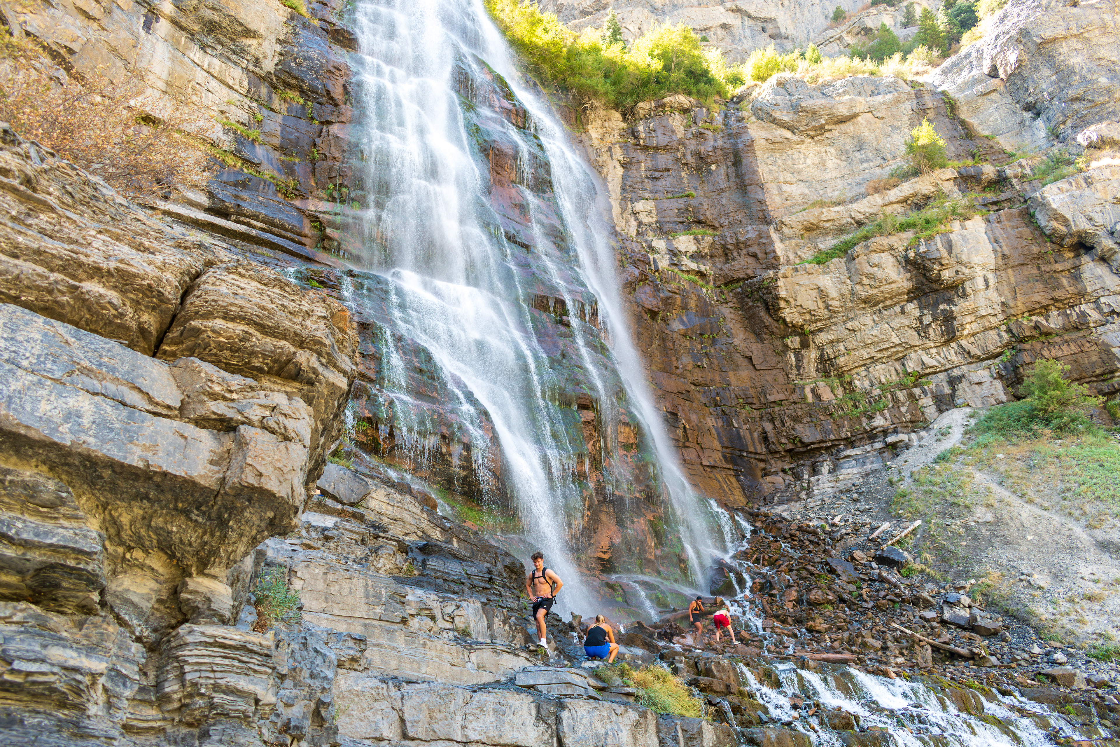 Provo, Utah, USA — September 1, 2025: Visitors gather at the base of Bridal Veil Falls as multiple streams of water cascade down the steep rock face.