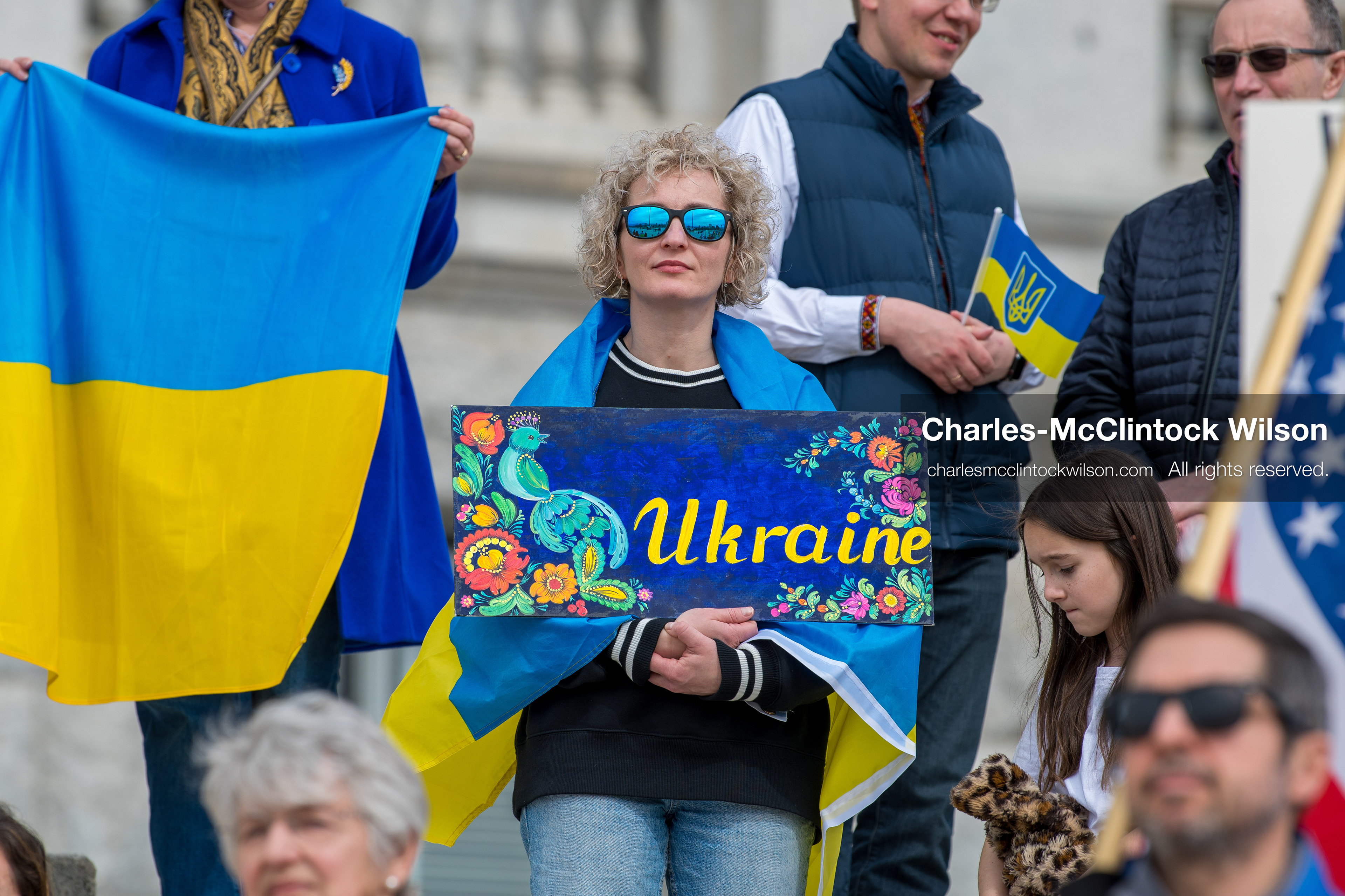  February 28, 2026, Salt Lake City, Utah, USA: A demonstrator draped in a Ukrainian flag holds a hand painted sign reading Ukraine during the Stand With Ukraine rally at the Utah State Capitol. The gathering marked the four year anniversary of the full scale Russian invasion of Ukraine and brought community members together in support of Ukrainians and local humanitarian efforts. (Credit Image: © Charles McClintock Wilson/ZUMA Press Wire)