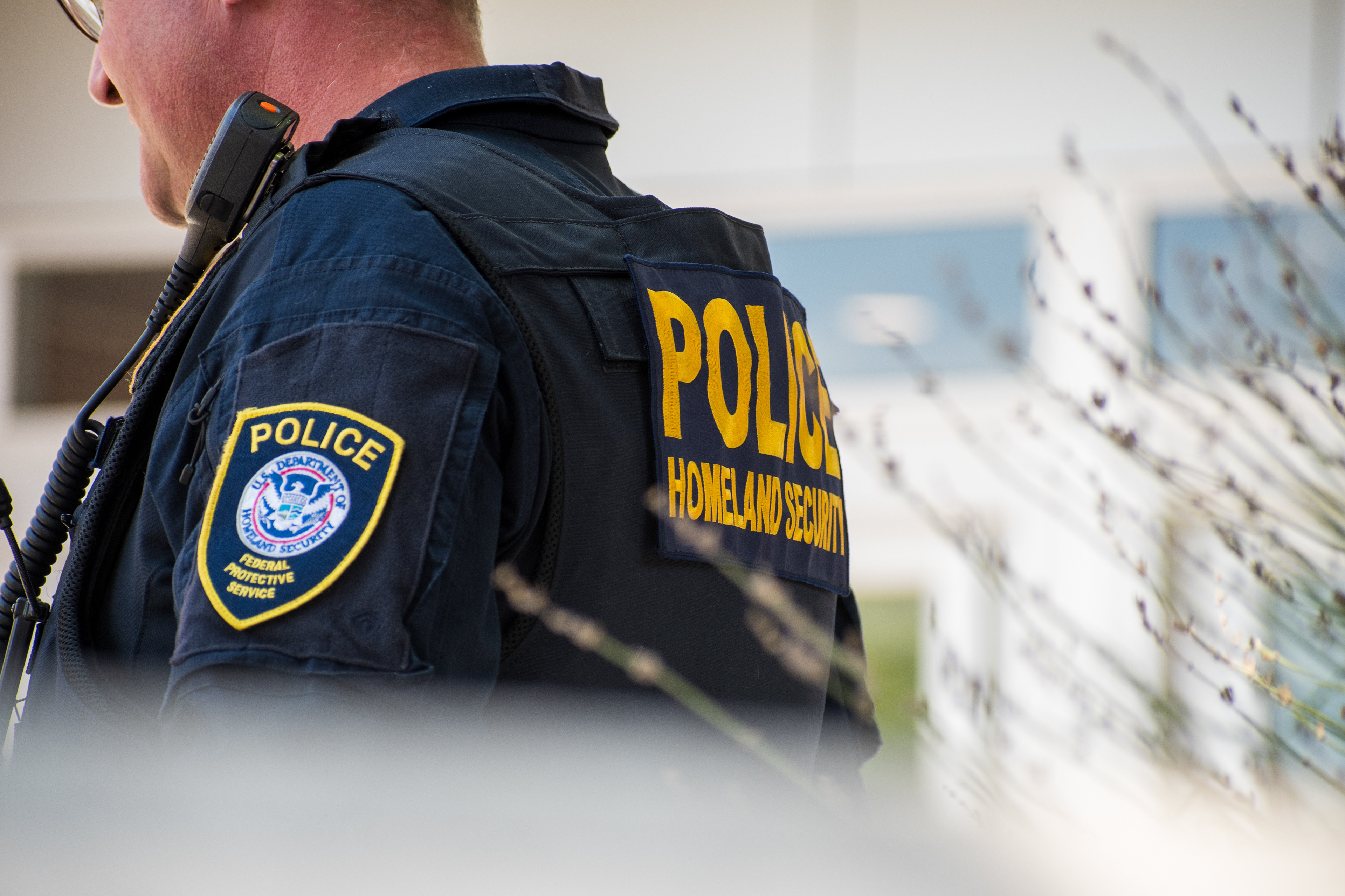 A Homeland Security police officer stands outside the Utah Valley Convention Center during the DHS Career Expo in Provo, Utah, on September 15, 2025. The tactical vest, marked “POLICE HOMELAND SECURITY,” reflects the agency’s visible perimeter presence as federal recruitment efforts intensified under expanded national security initiatives. Photograph by Charles‑McClintock Wilson / ZUMA Press Wire