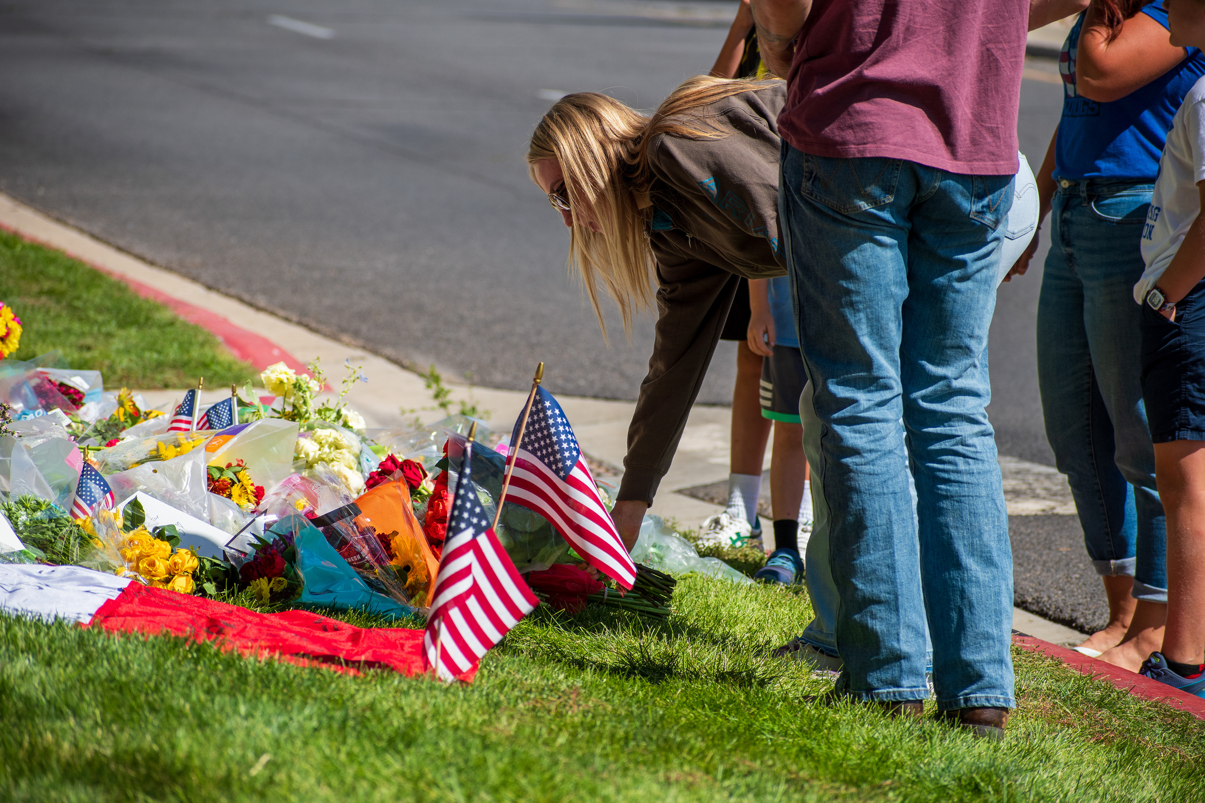 OREM, UTAH – SEPTEMBER 12, 2025: Families gather at a memorial site for Charlie Kirk on the campus of Utah Valley University. The tribute includes American flags, balloons, flowers, and handwritten posters arranged near a building entrance. © Charles‑McClintock Wilson / ZUMA Press