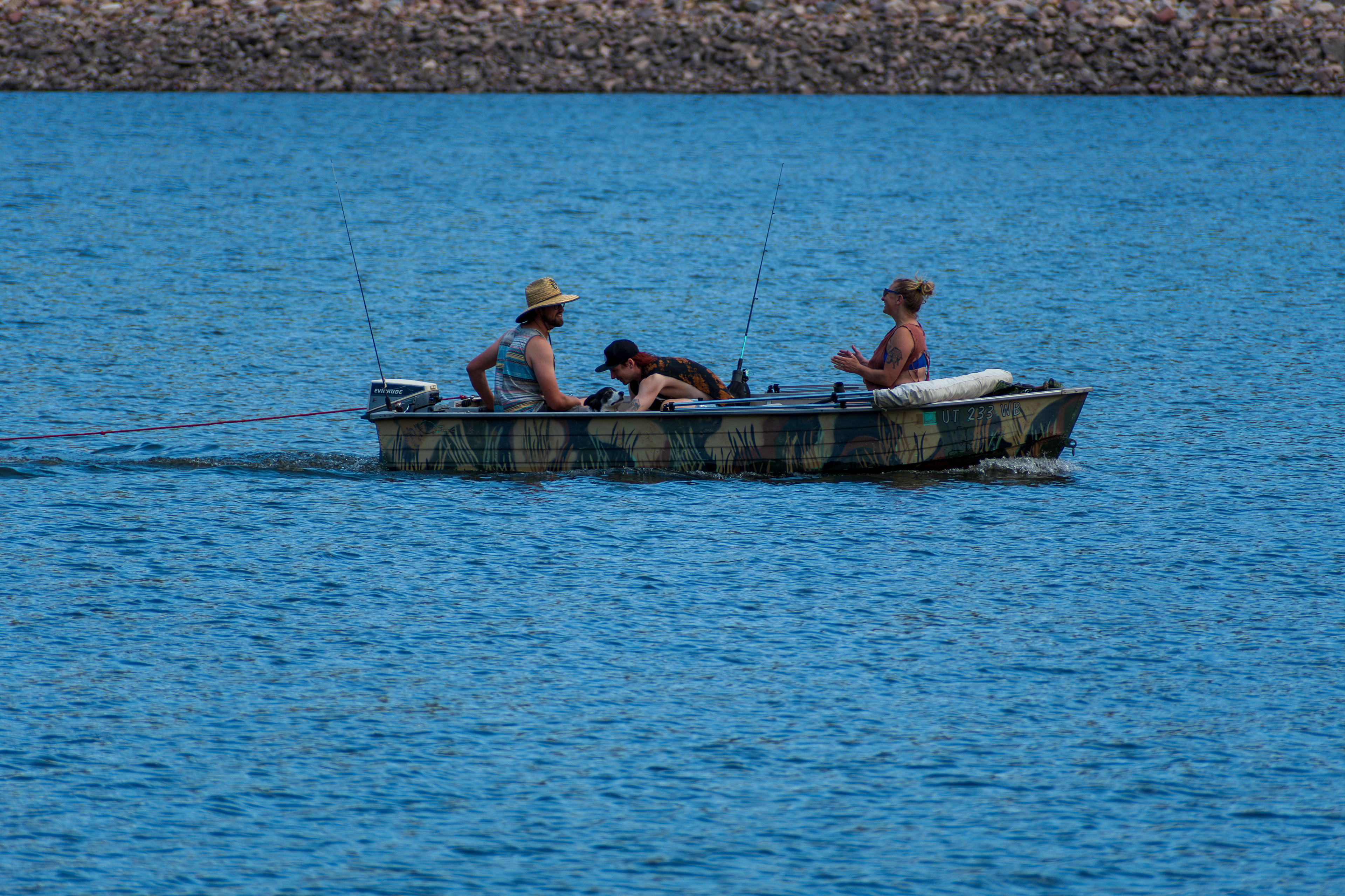 Summit County, Utah – July 20, 2025: People fish from a small boat on the calm waters of Smith and Morehouse Reservoir during a peaceful summer day.