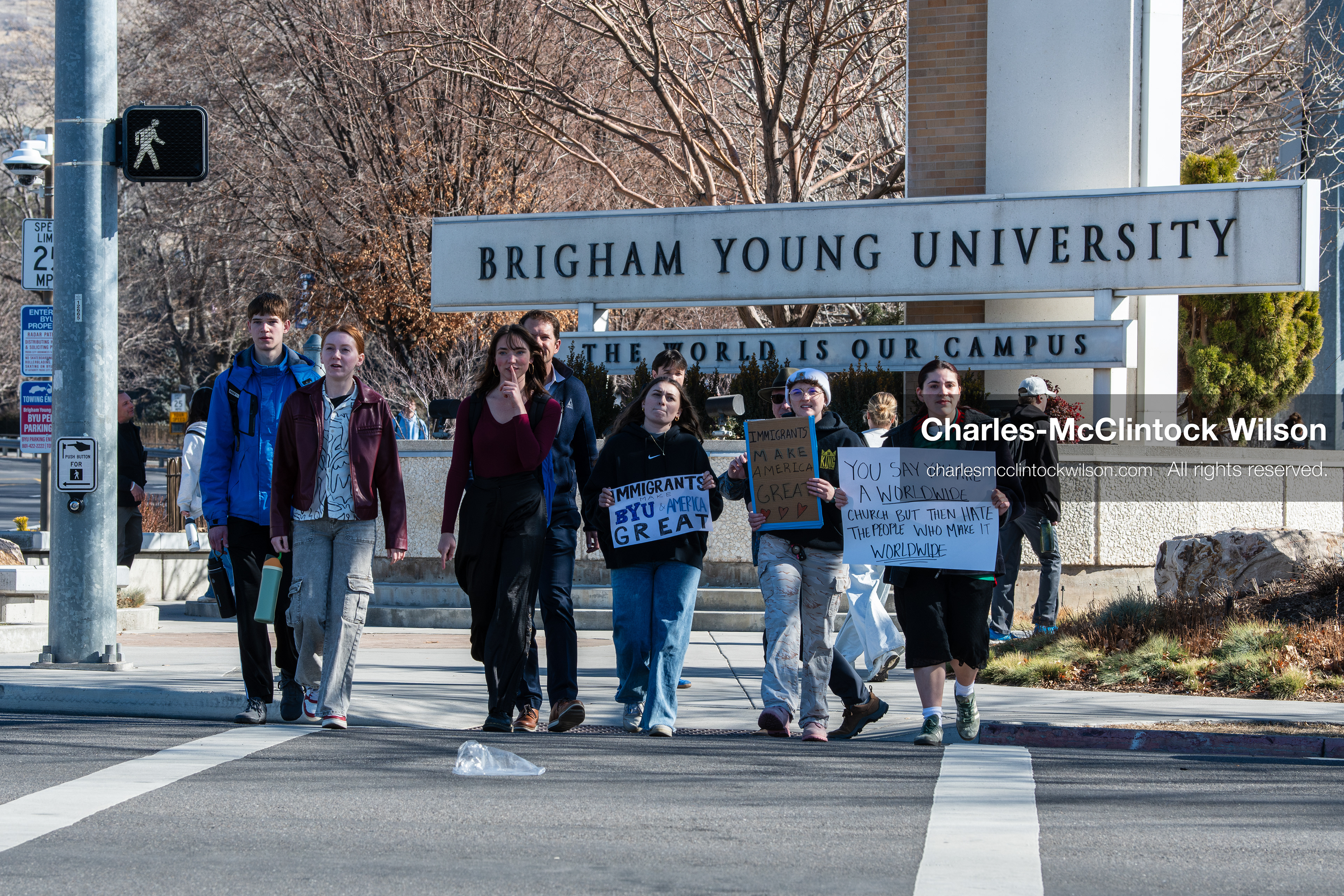 February 5, 2026, Provo, Utah, USA: People walk near the Brigham Young University entrance in Provo as demonstrators carrying signs gather to protest the presence of US Customs and Border Protection recruiters at a career fair held on the BYU campus. (Credit Image: © Charles McClintock Wilson/ZUMA Press Wire)