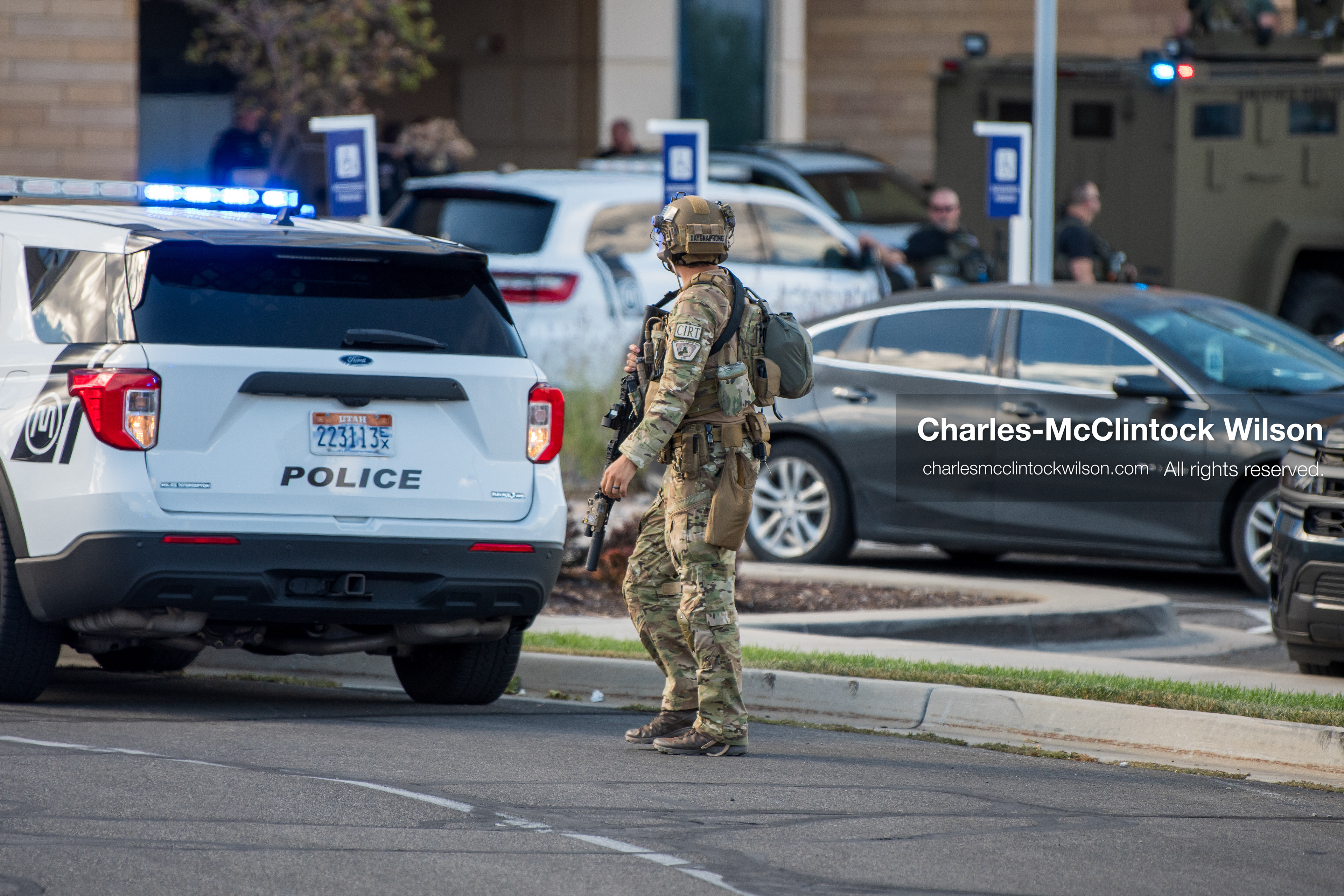 An armed law enforcement officer wearing a helmet and tactical gear stands guard outside Intermountain Medical Center in Murray, Utah, on Monday, August 17, 2026. Multiple regional law enforcement agencies converged to heavily secure the hospital perimeter as a safety precaution after shooting victims arrived from a fatal shootout that erupted outside a funeral service in nearby Kearns earlier that day. (Photo by Charles-McClintock Wilson/Sipa USA)
