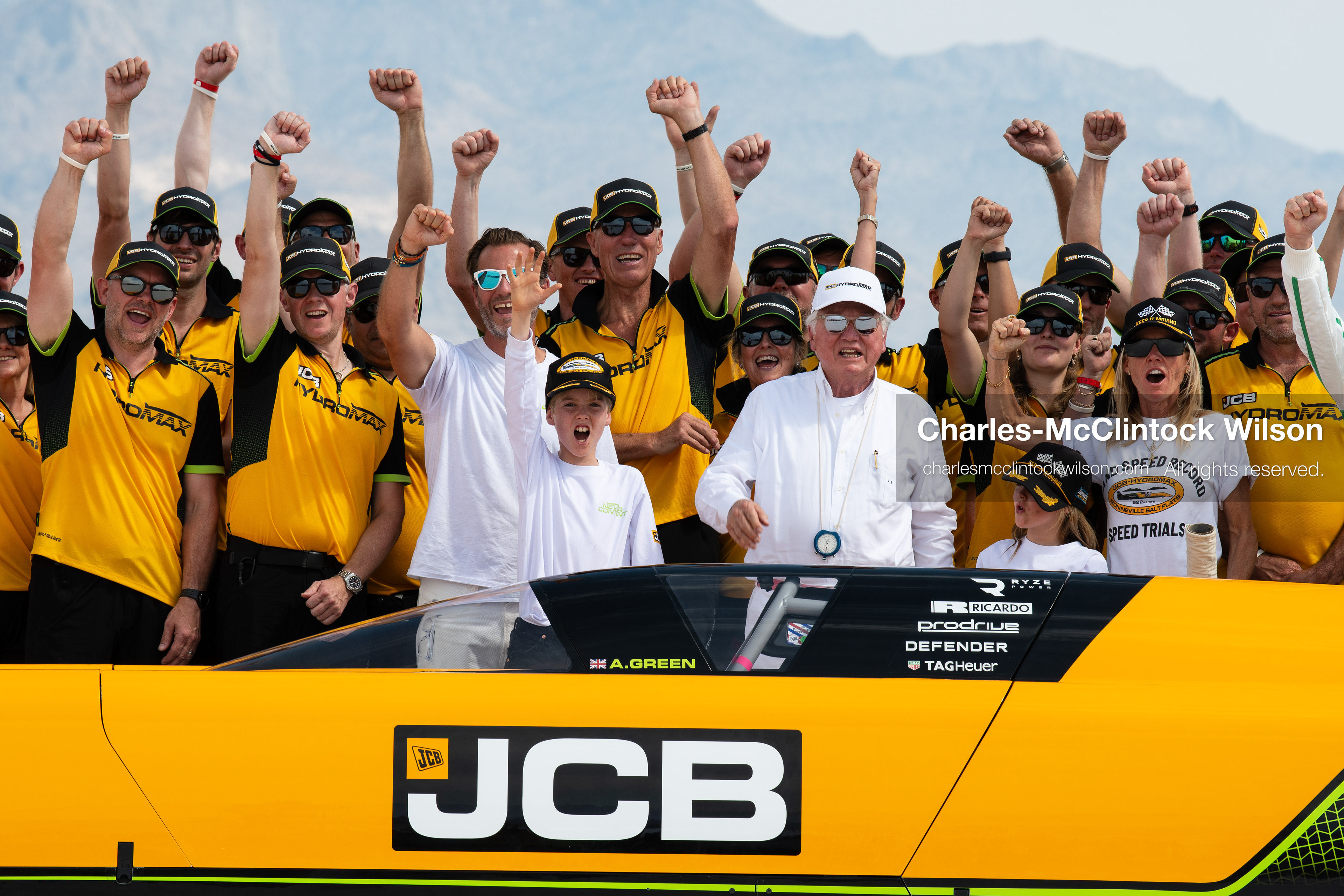 British pilot Andy Green and JCB Chairman Anthony Bamford raise their fists and cheer with members of the JCB engineering team behind the cockpit of the "JCB Hydromax" on the Bonneville Salt Flats on Tuesday. The team celebrated setting a new hydrogen land speed record of 406.320 mph. (Photo by Charles-McClintock Wilson/Sipa USA)