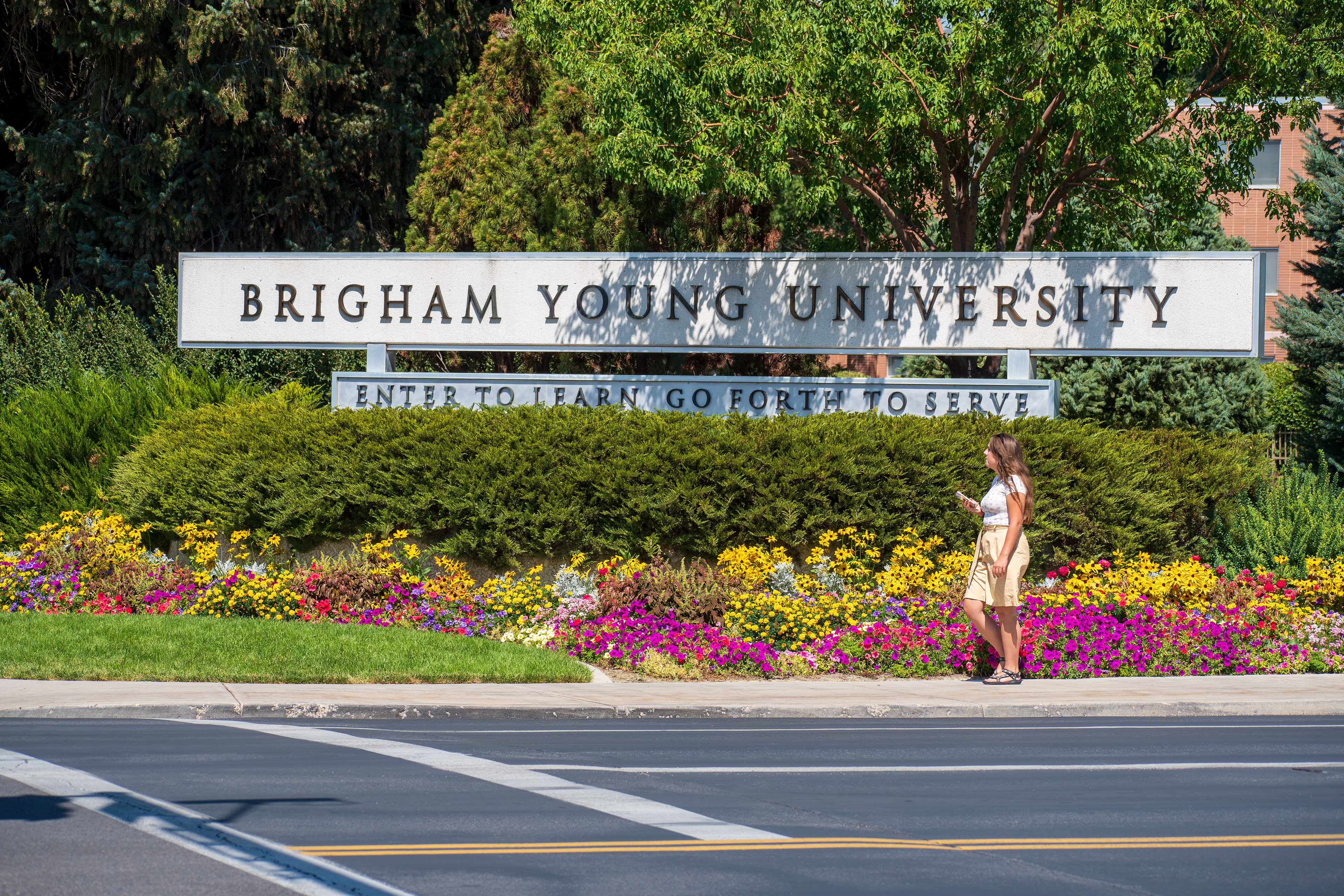 Provo, Utah – September 1, 2025: A woman passes the entrance to Brigham Young University, a private university operated by The Church of Jesus Christ of Latter-day Saints.