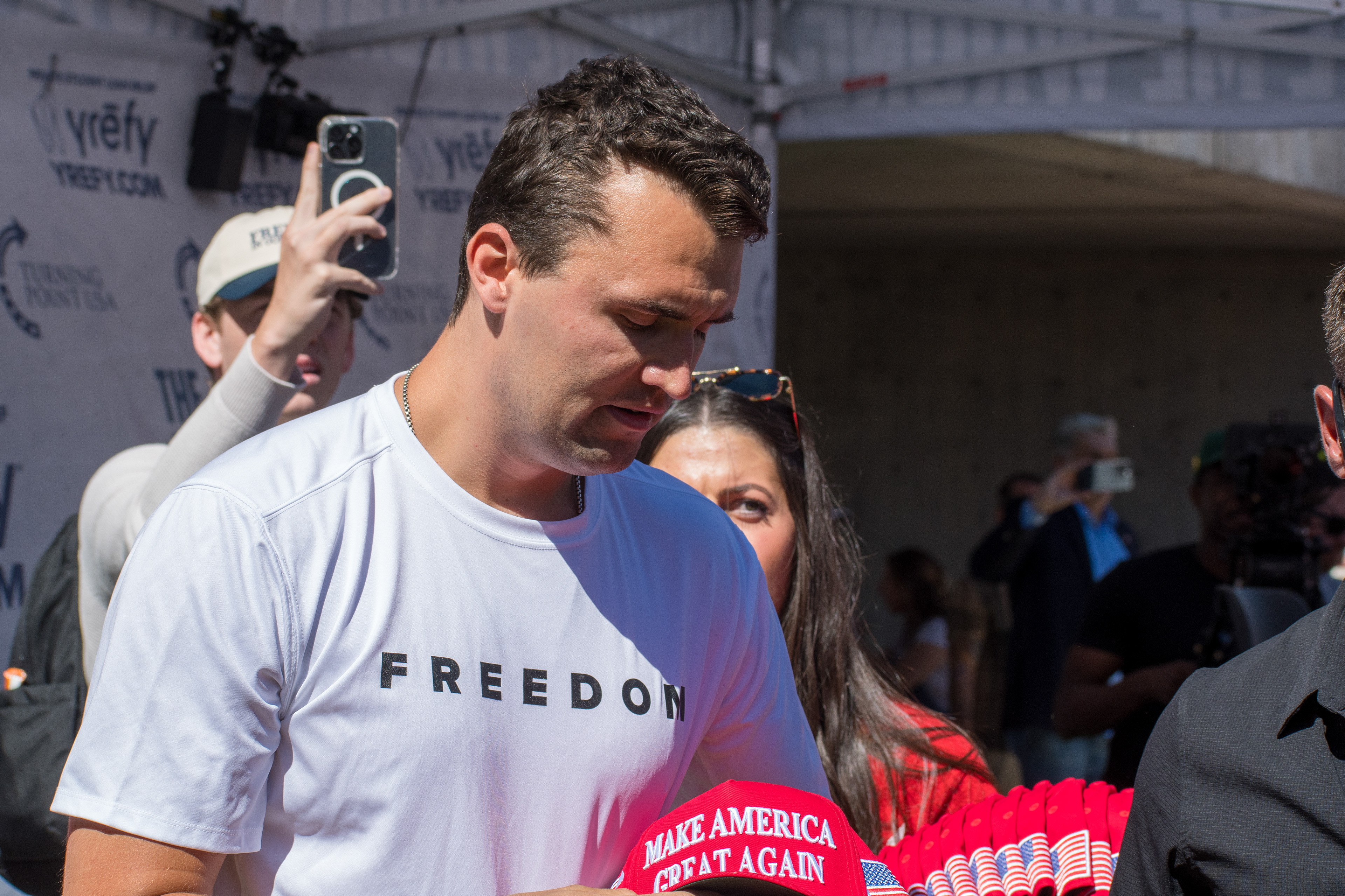 OREM, UTAH – SEPTEMBER 10, 2025: Charlie Kirk speaks with attendees during a public event at Utah Valley University. Positioned near a promotional booth and surrounded by supporters, Kirk appears engaged and expressive in one of his final public moments. The image reflects the atmosphere of direct outreach and energized dialogue that defined the gathering. © Charles-McClintock Wilson / ZUMA Press