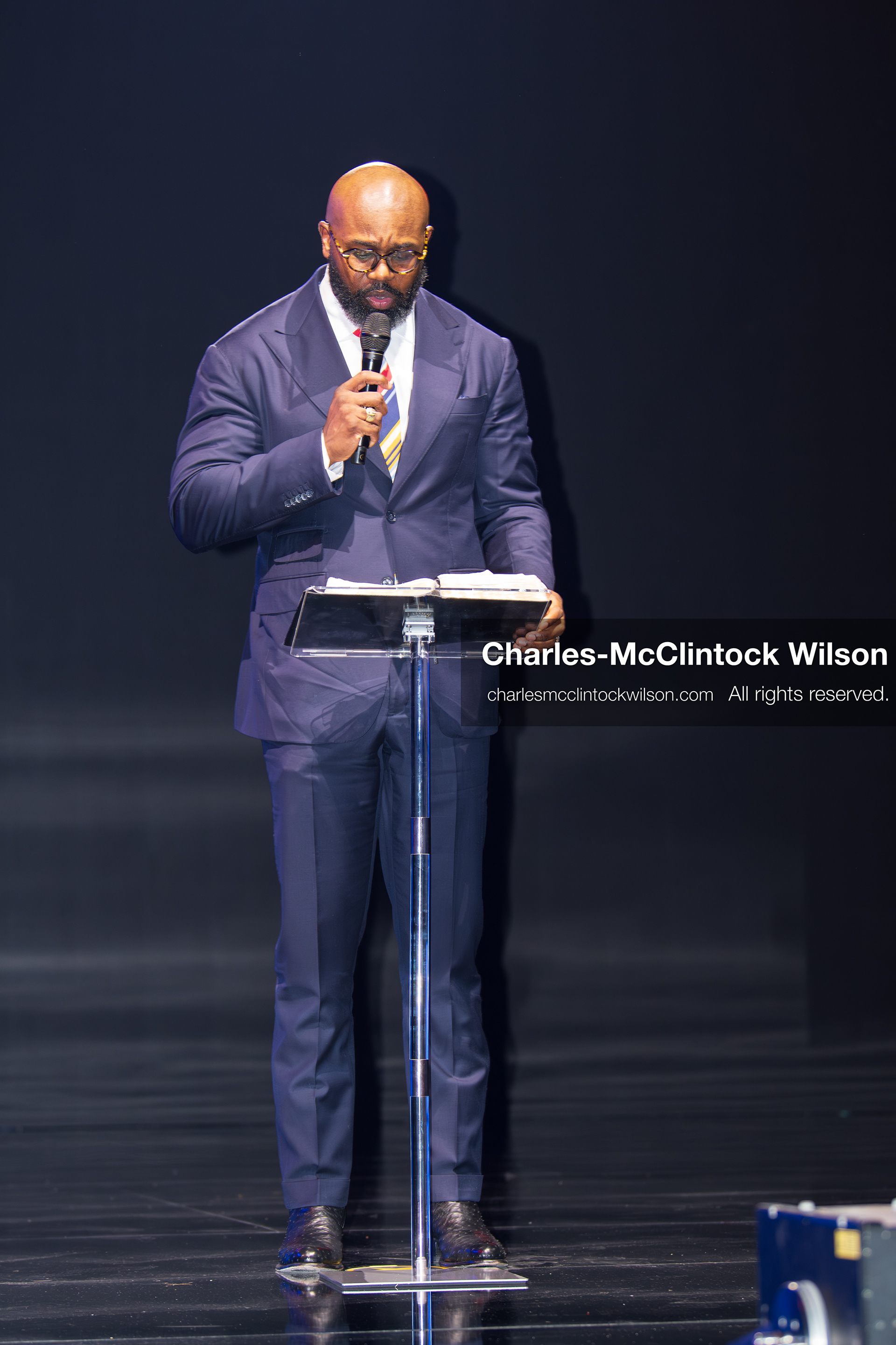 December 18, 2025, Phoenix, Arizona, USA: Pastor John Amanchukwu speaks on stage during AmericaFest 2025 at the Phoenix Convention Center, holding a microphone behind a transparent podium. (Credit Image: (c) Charles-McClintock Wilson/ZUMA Press Wire)