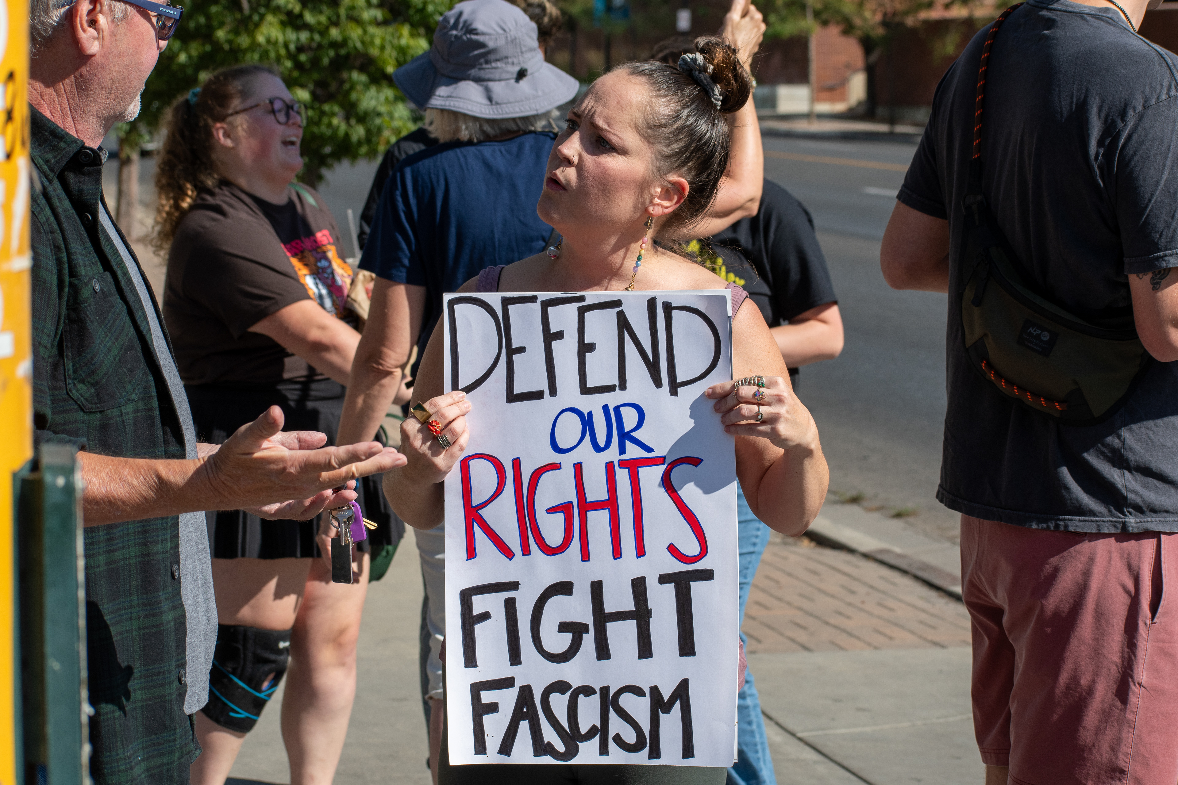 September 15, 2025 – Provo, Utah, United States: A demonstrator holds a sign reading “DEFEND OUR RIGHTS FIGHT FASCISM” outside the Utah Valley Convention Center during a protest against the Department of Homeland Security career expo. The scene captures a moment of civic dialogue as protestors engage in public discussion over federal enforcement and civil liberties. Photograph by Charles‑McClintock Wilson / ZUMA Press Wire