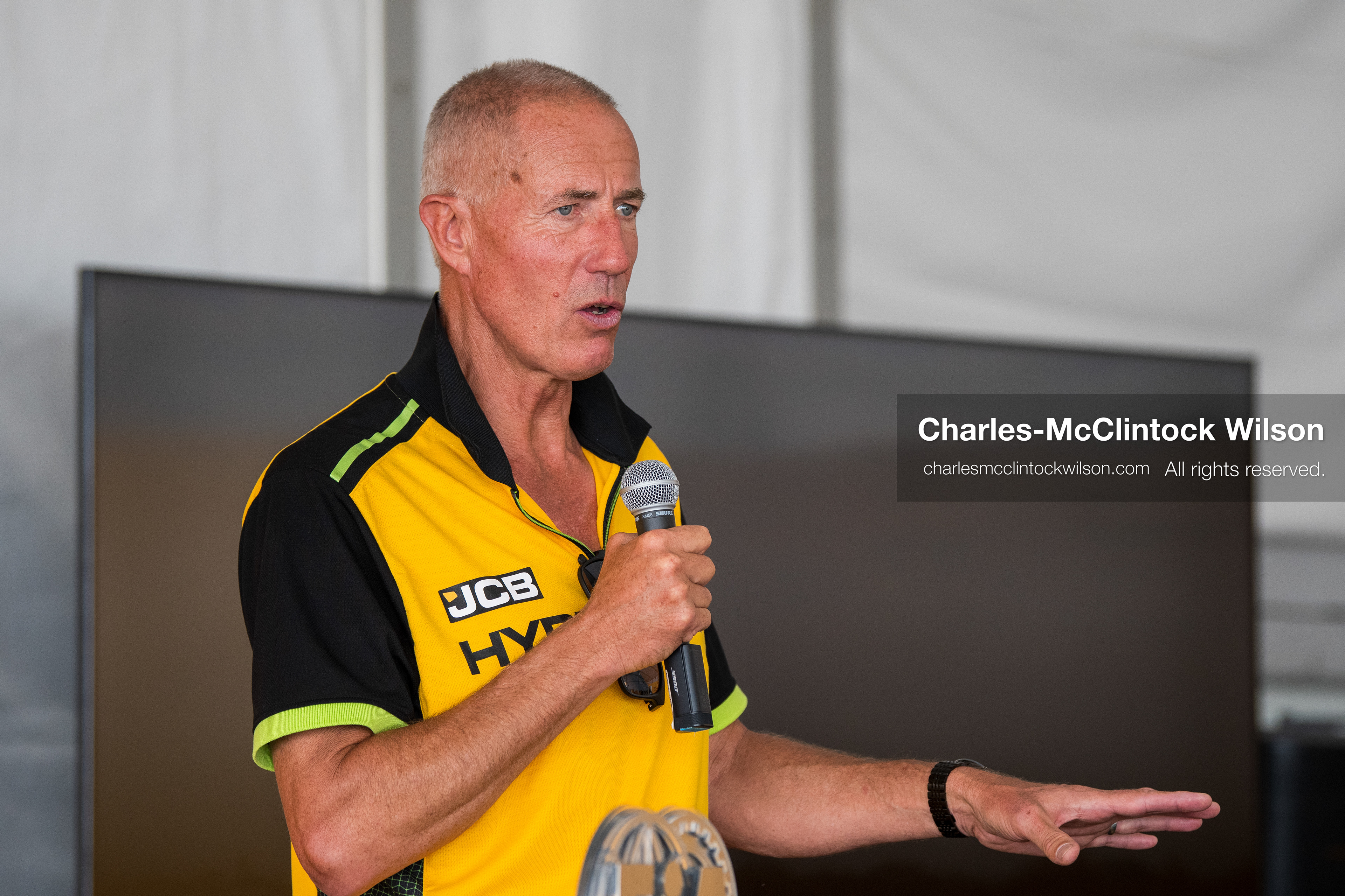 British pilot Andy Green speaks into a microphone during a press conference on the Bonneville Salt Flats on Tuesday. Green steered the hydrogen-powered "JCB Hydromax" streamliner to a historic record-breaking top speed of 406.320 mph during official speed trials. (Photo by Charles-McClintock Wilson/Sipa USA)