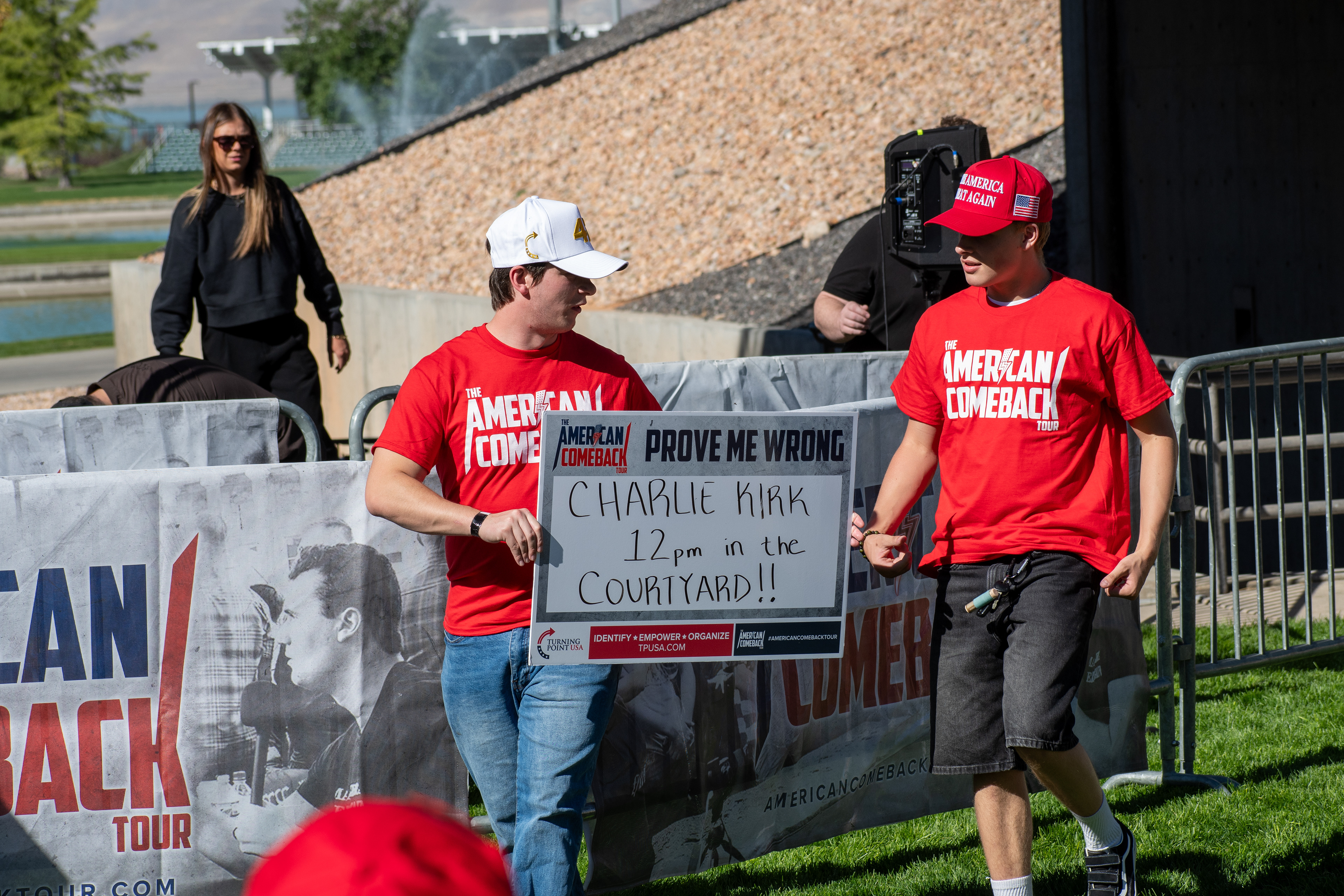 OREM, UTAH – SEPTEMBER 10, 2025: Attendees hold signage and wear matching red shirts at Utah Valley University during the opening stop of the American Comeback Tour. Positioned near the courtyard, the group reflects a moment of coordinated presence and public invitation. The image captures the visual messaging and communal energy that shaped the event’s atmosphere. © Charles-McClintock Wilson / ZUMA Press