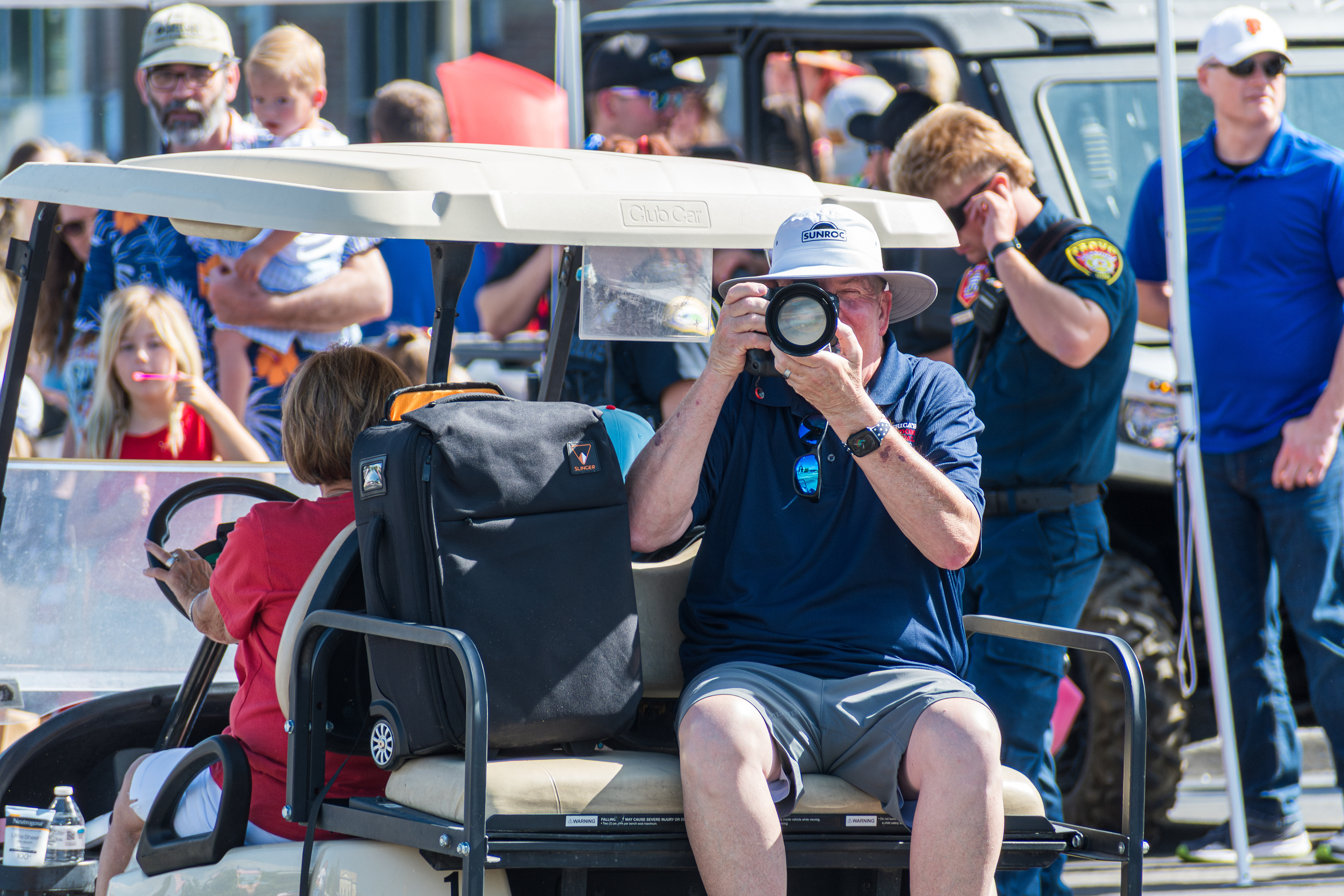 Provo, Utah – July 4, 2025: A photographer rides in a golf cart taking photos during the Freedom Festival Grand Parade in downtown Provo.