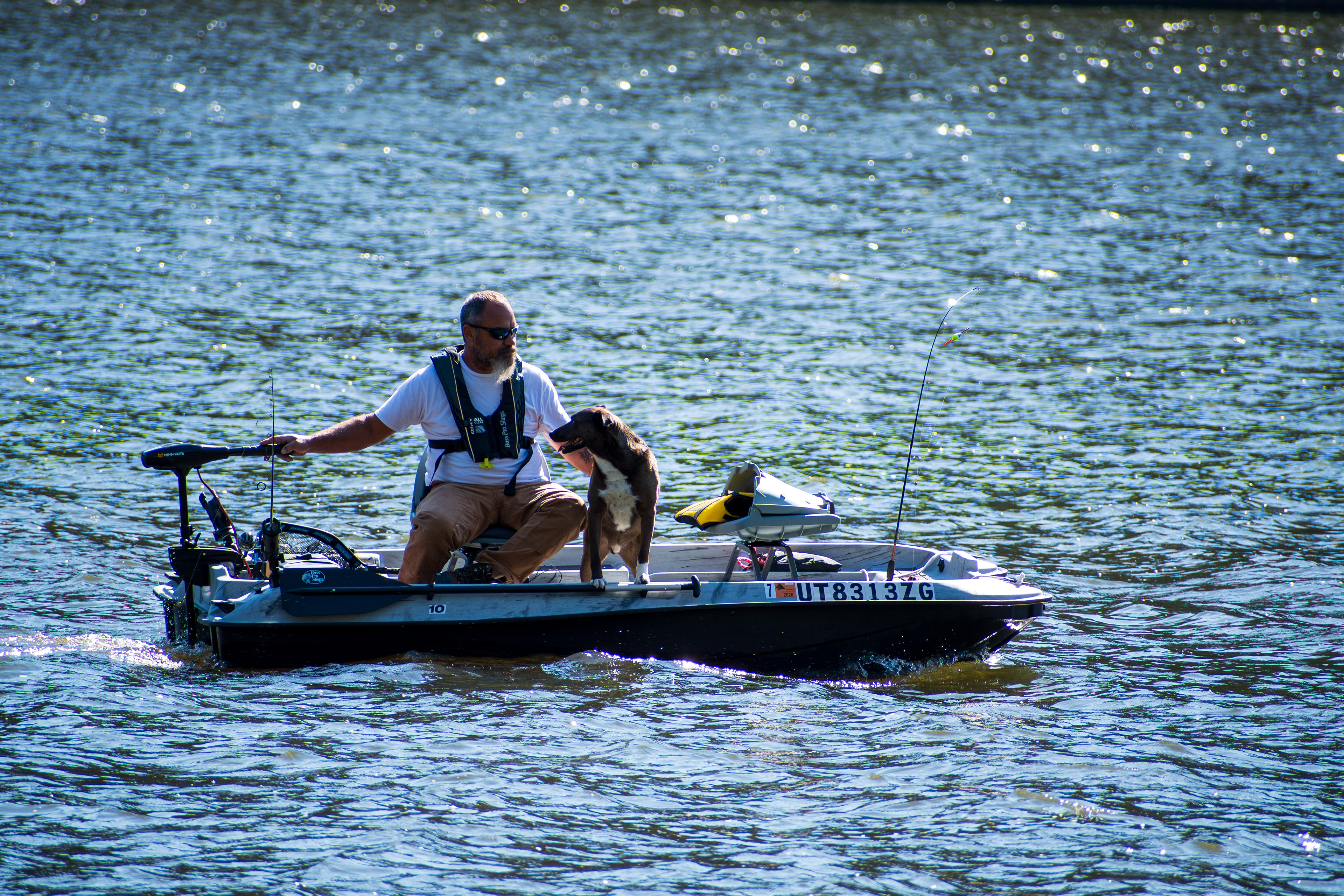 Summit County, Utah – July 20, 2025: A man and his dog ride together on a small boat at Smith and Morehouse Reservoir.