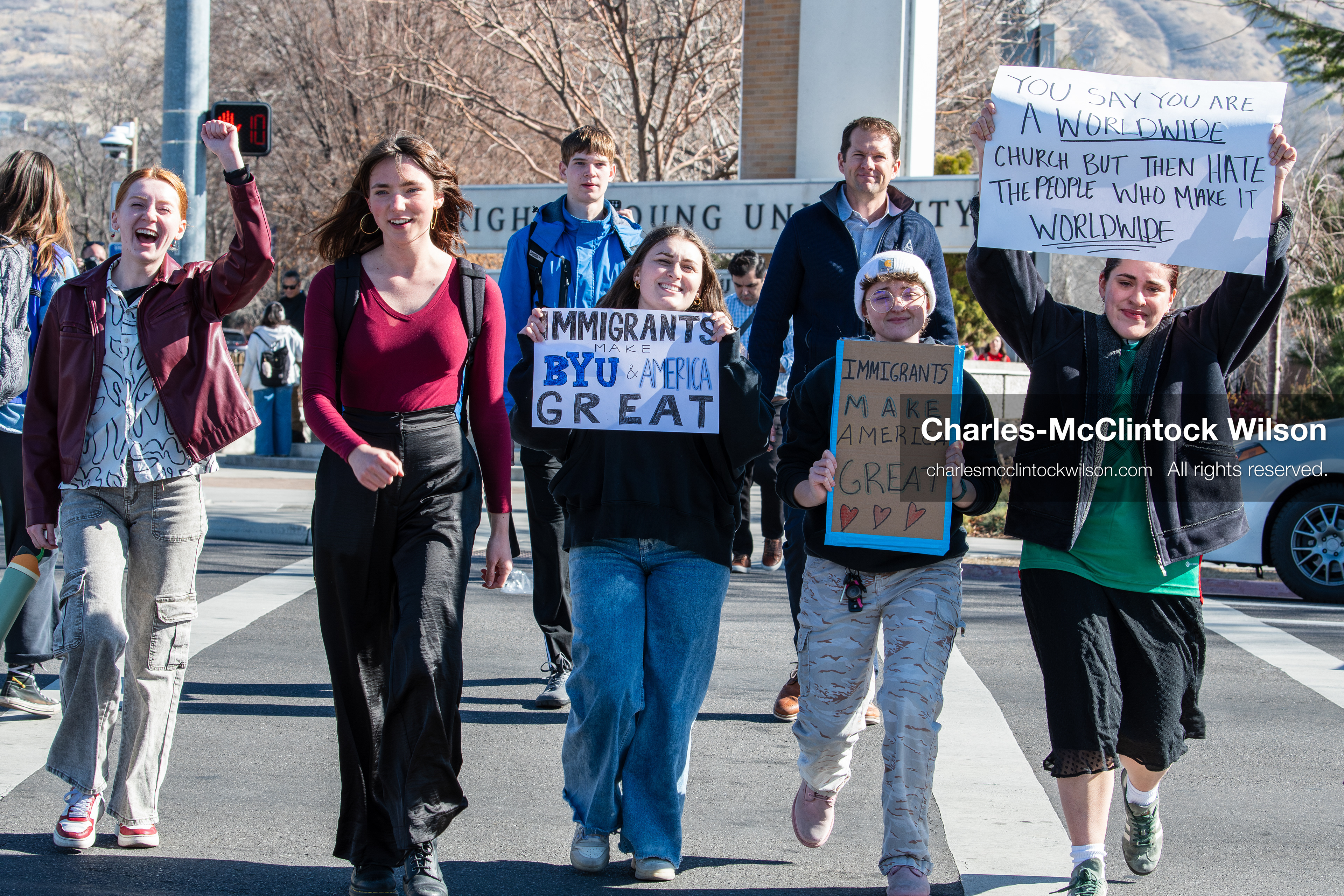 February 5, 2026, Provo, Utah, USA: People walk near the Brigham Young University entrance in Provo as demonstrators carrying signs gather to protest the presence of US Customs and Border Protection recruiters at a career fair held on the BYU campus. (Credit Image: © Charles McClintock Wilson/ZUMA Press Wire)