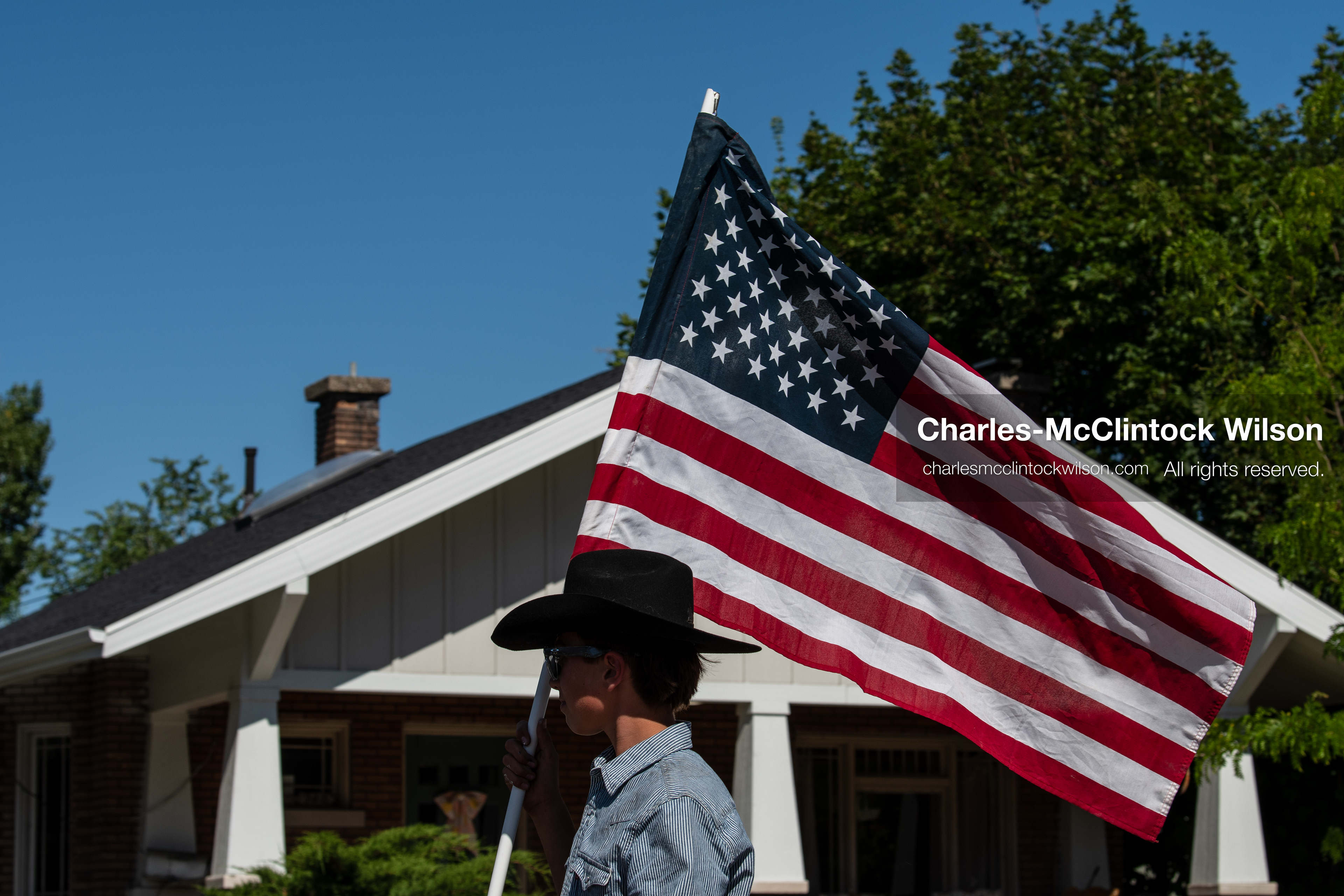 July 4, 2026, Provo, Utah, USA: A parade participant wearing a cowboy hat carries an American flag past a home along the route during America's Freedom Festival Grand Parade in Provo, Utah, Saturday, July 4, 2026. The annual event drew thousands of spectators to the downtown corridor. (Credit Image: © Charles-McClintock Wilson/ZUMA Press Wire)