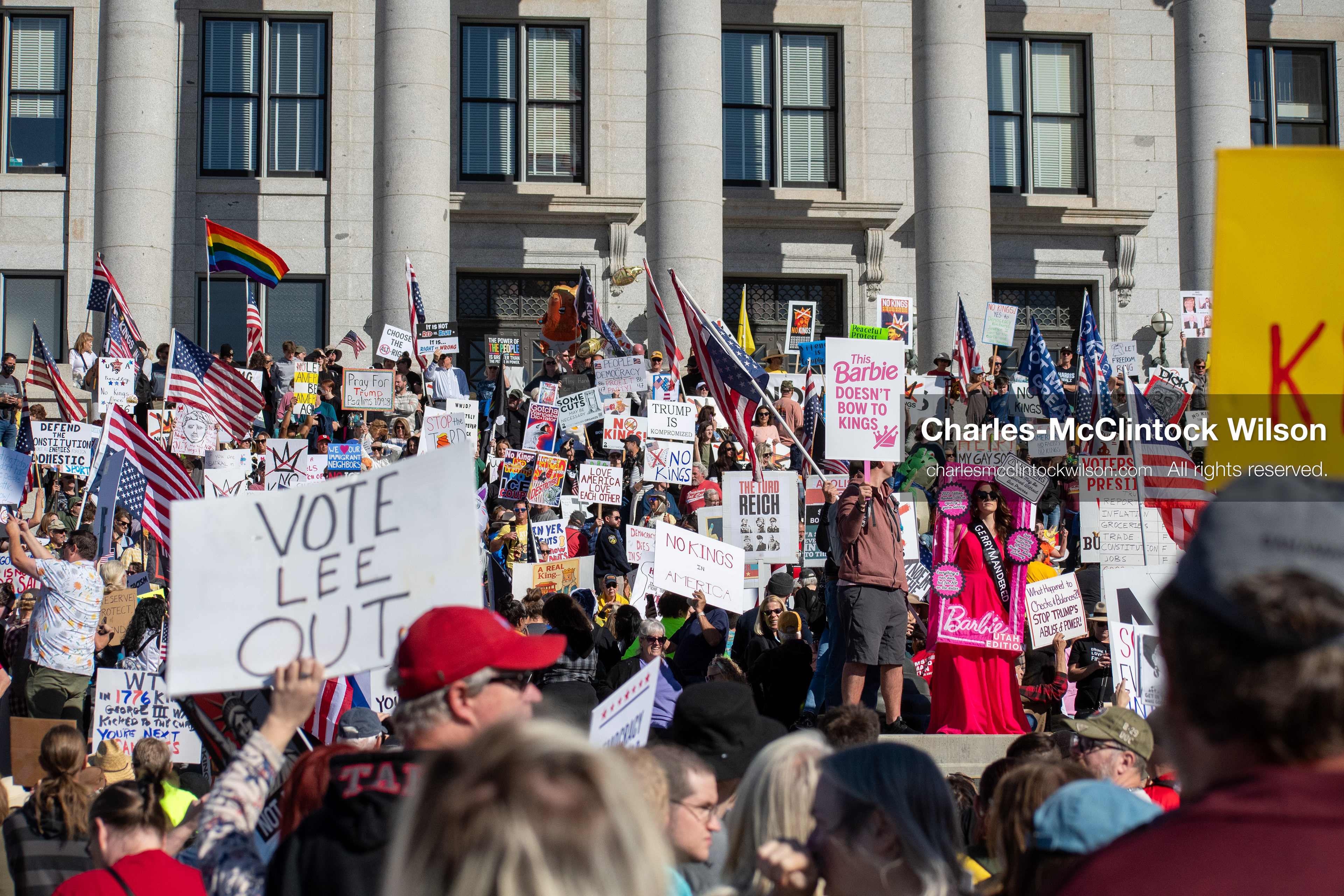 October 18, 2025, Salt Lake City, Utah, USA: Demonstrators gather on the steps of the Utah State Capitol during a "No Kings" protest held as part of a nationwide mobilization. Participants hold signs and flags while documenting the event. The protest was one of several organized across the United States.