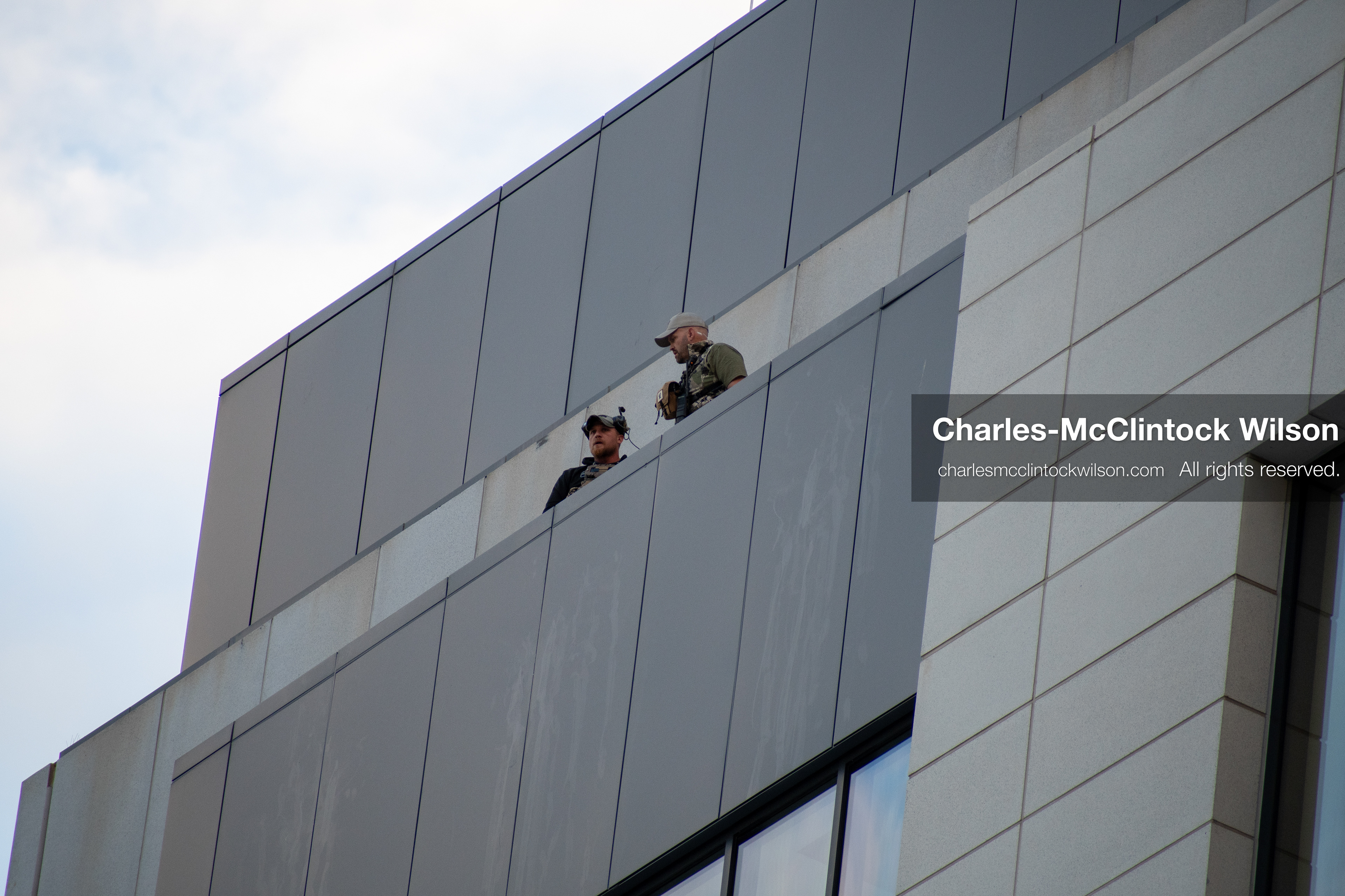 SEPTEMBER 29, 2025 — PROVO, UTAH, USA: Two law enforcement officers stand atop the Utah County Court during a waiver hearing for Tyler Robinson. Robinson, charged with aggravated murder in the September 10 shooting death of conservative activist Charlie Kirk at Utah Valley University, appeared virtually for the proceedings. Officers maintained elevated positions as the hearing unfolded. (Credit Image: © Charles‑McClintock Wilson / ZUMA Press Wire)
