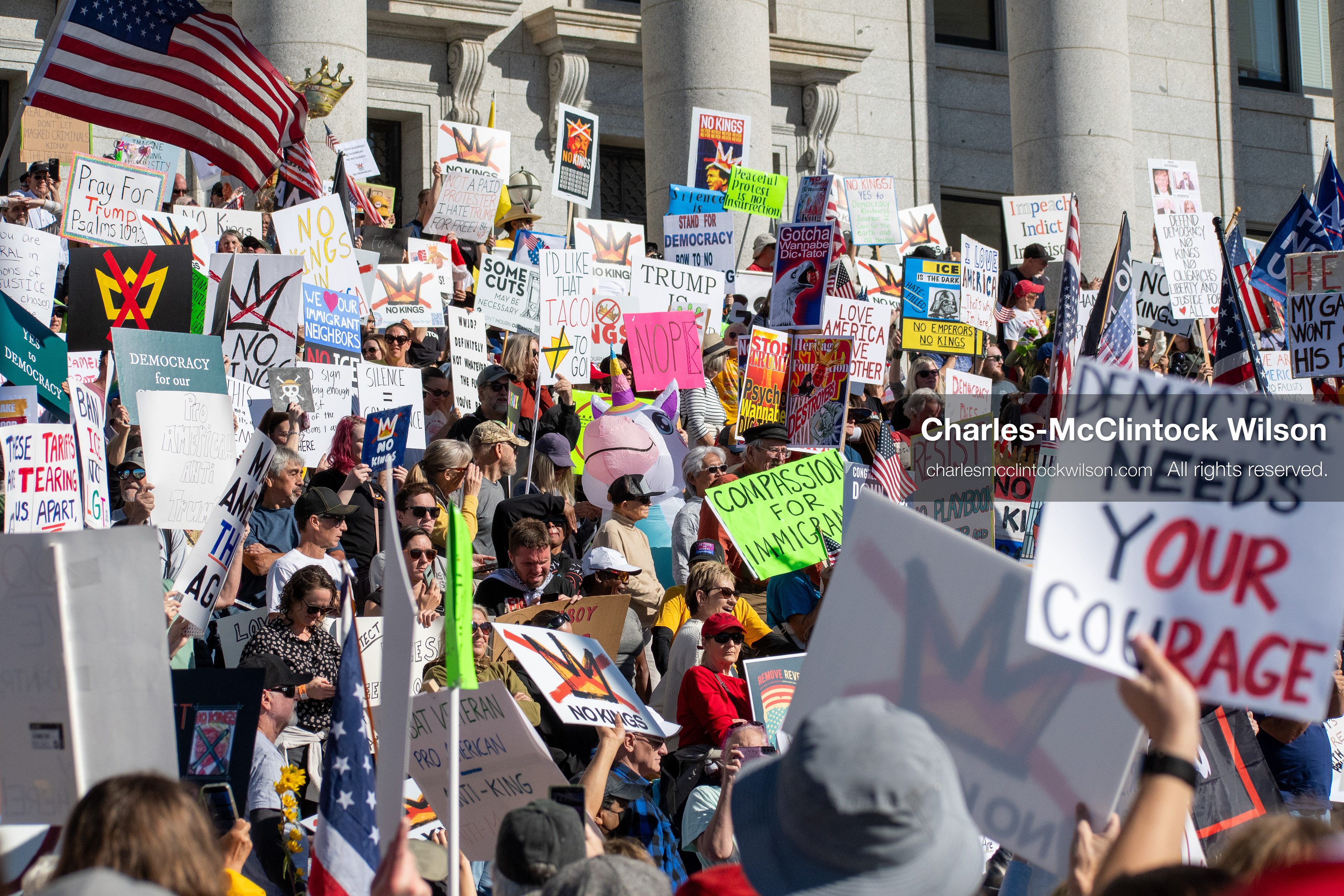October 18, 2025, Salt Lake City, Utah, USA: Demonstrators gather on the steps of the Utah State Capitol during a "No Kings" protest held as part of a nationwide mobilization. Participants hold signs and flags while documenting the event. The protest was one of several organized across the United States.