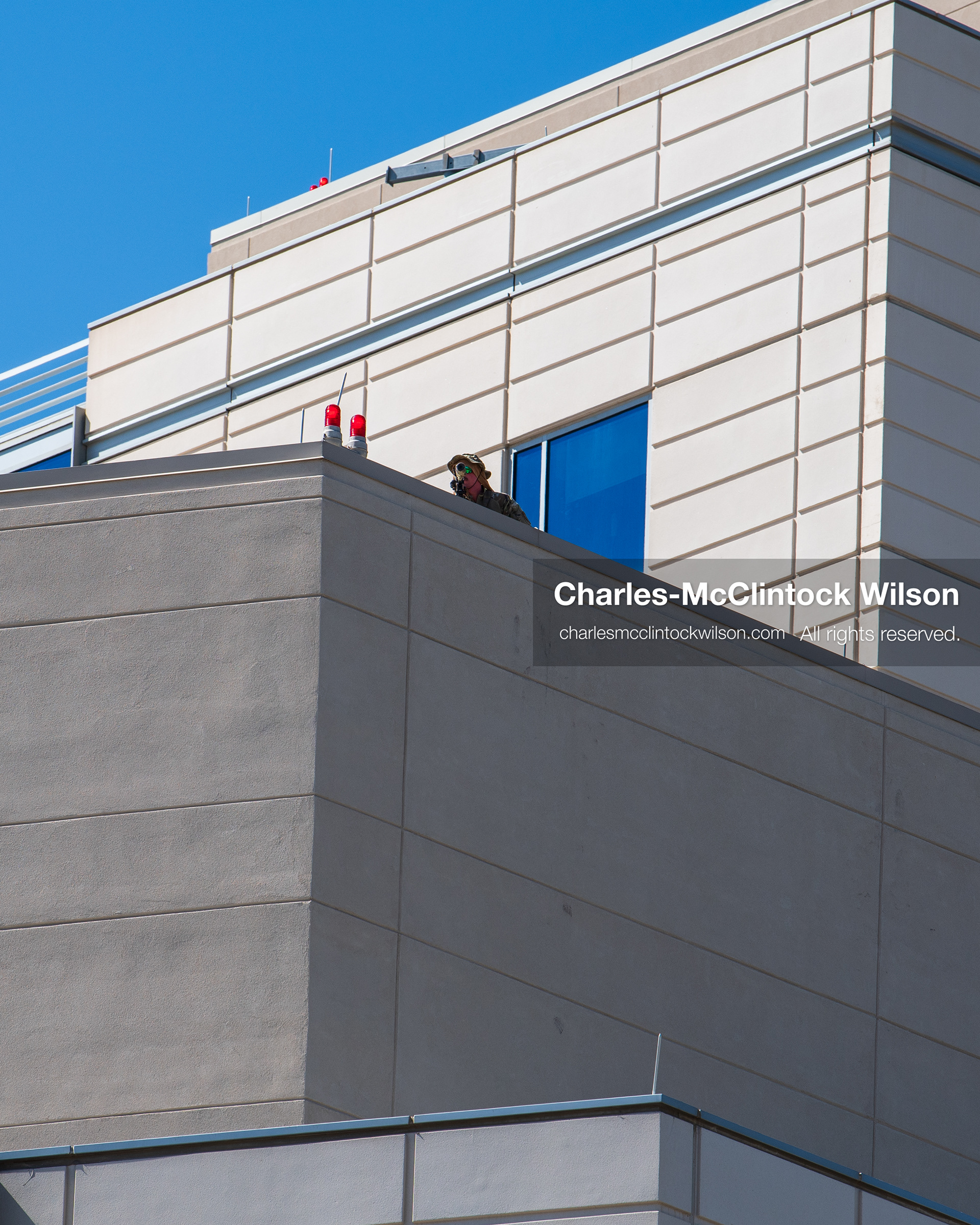 A law enforcement officer stands watch from an elevated rooftop position on the exterior building facade of Intermountain Medical Center in Murray, Utah, on Monday, August 17, 2026. Multiple regional law enforcement agencies converged to heavily secure the hospital perimeter as a safety precaution after shooting victims arrived from a fatal shootout that erupted outside a funeral service in nearby Kearns earlier that day. (Photo by Charles-McClintock Wilson/Sipa USA)