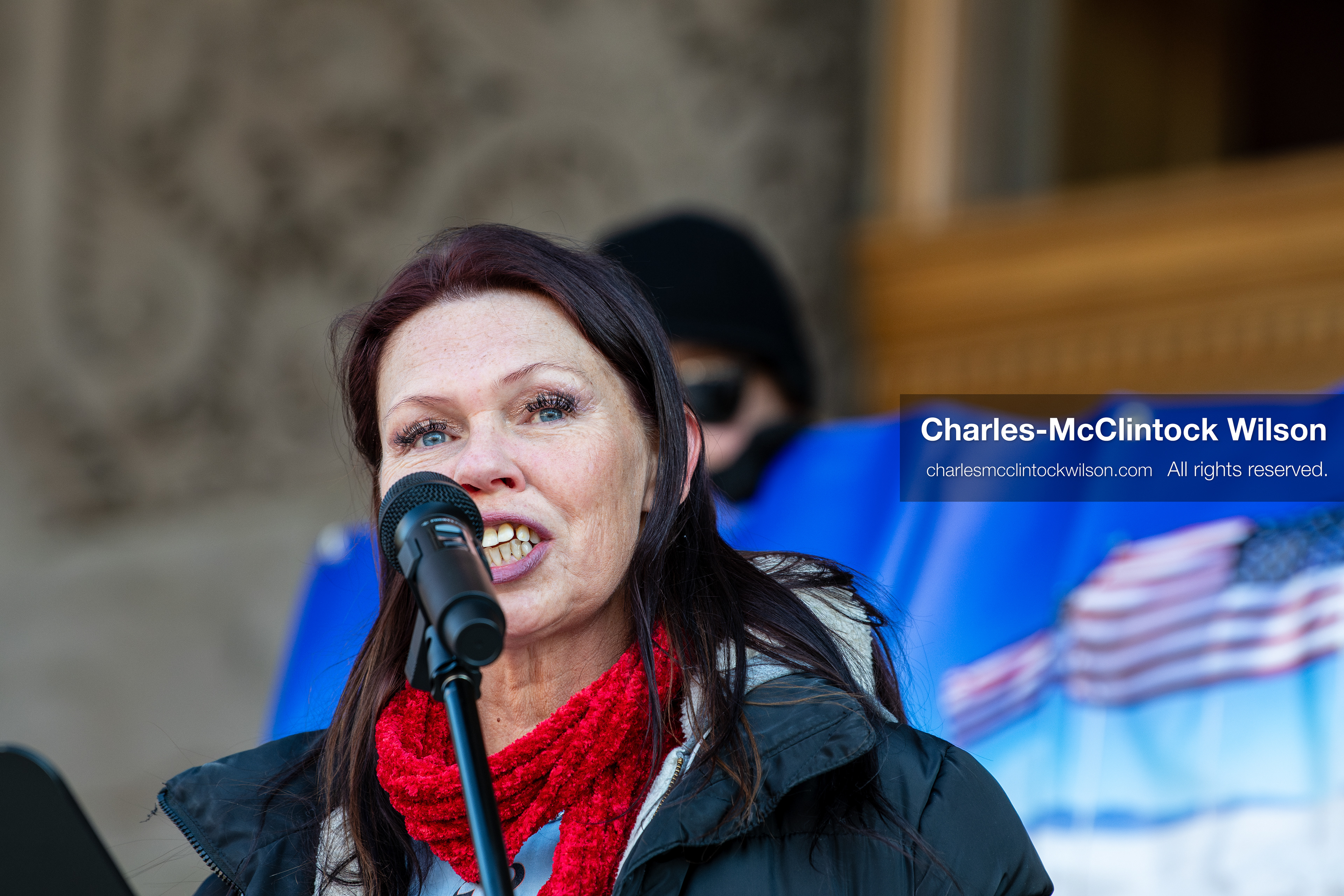 Salt Lake City, Utah, January 10, 2026: A speaker addresses the crowd during the ICE Out for Good protest at Washington Square Park, a demonstration calling for justice for Renee Nicole Good. Behind the speaker, a supporter holds a banner featuring an American flag. (Credit Image: © Charles‑McClintock Wilson/ZUMA Press Wire)