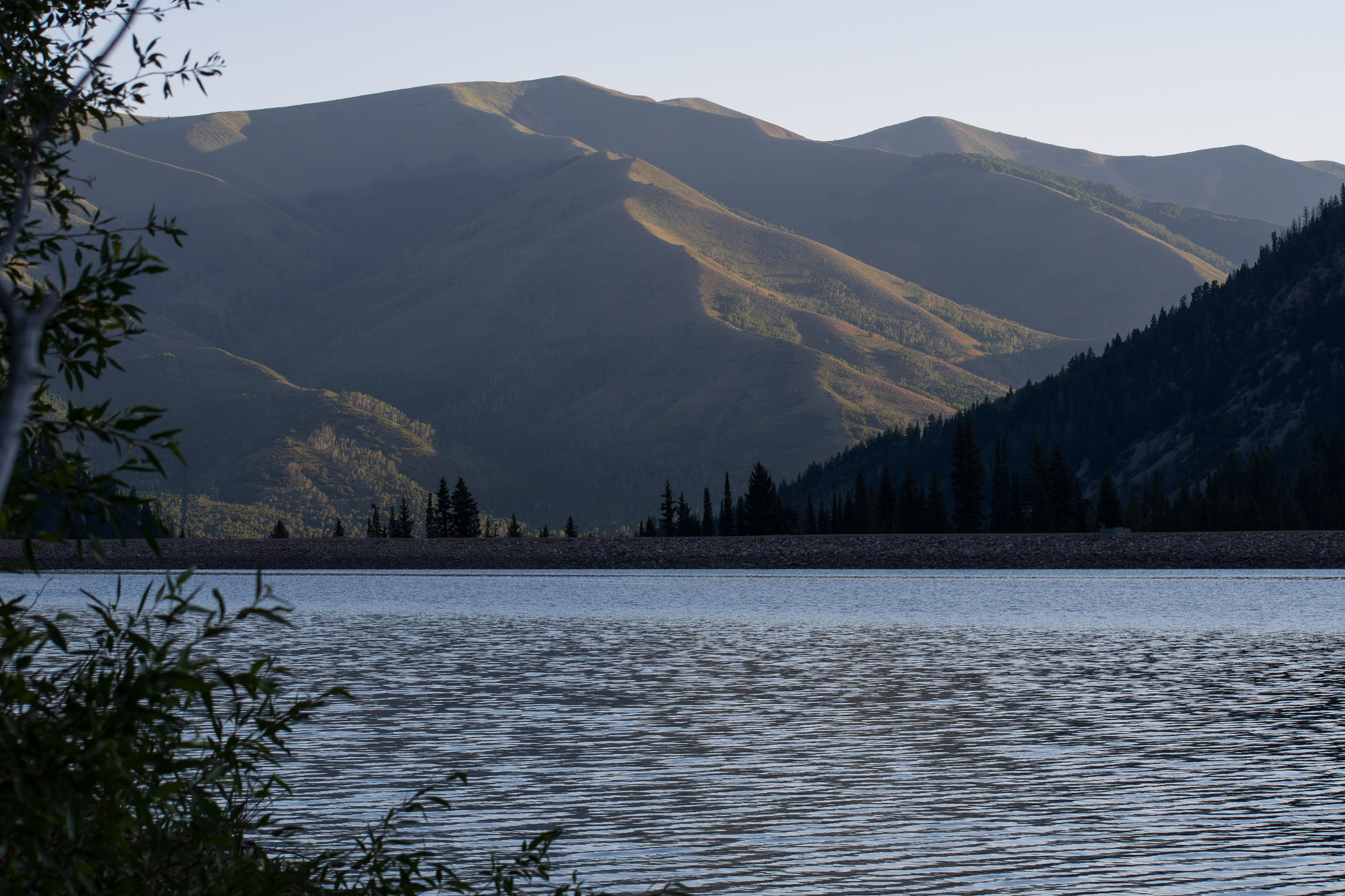 Summit County, Utah – July 20, 2025: A scenic view of Smith and Morehouse Reservoir with forested mountains rising in the background. 