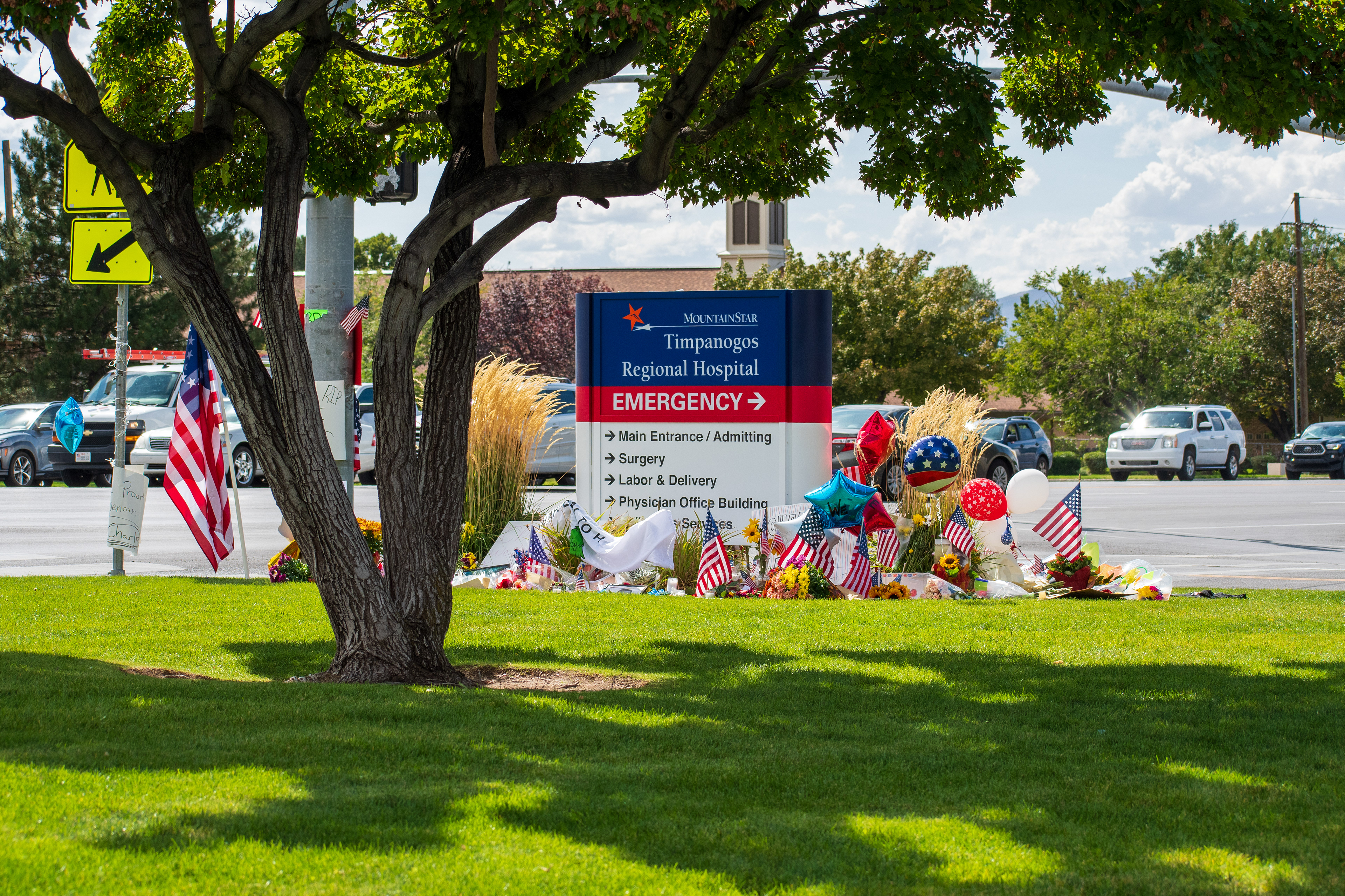 OREM, UTAH – SEPTEMBER 12, 2025: A memorial site for Charlie Kirk is seen in front of the MountainStar Timpanogos Regional Hospital sign near the Emergency Room entrance. American flags, balloons, flowers, and decorative items are arranged on the grass beside the roadside. © Charles‑McClintock Wilson / ZUMA Press