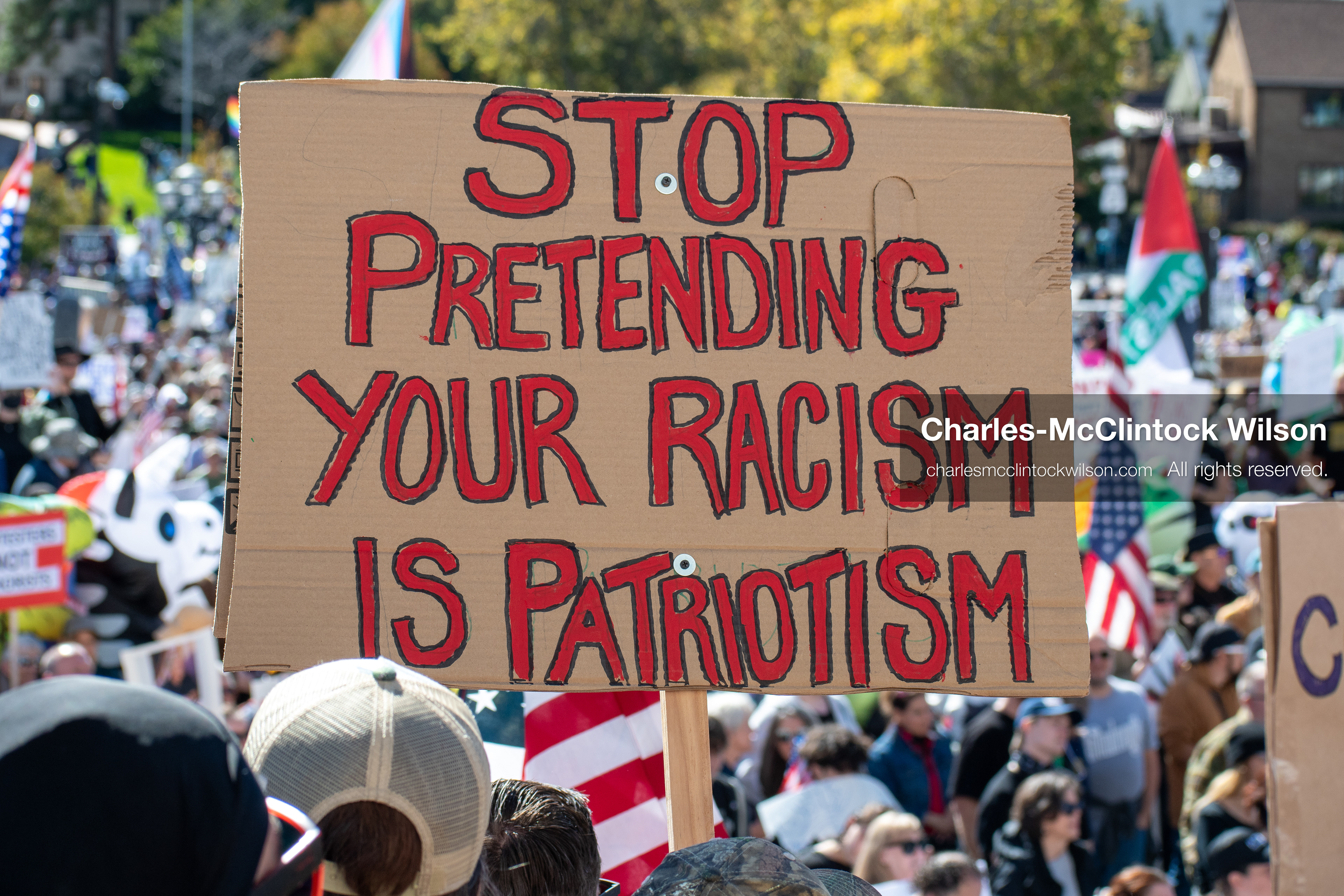 October 18, 2025, Salt Lake City, Utah, USA: A demonstrator raises a placard during a "No Kings" protest held at the Utah State Capitol. Other participants and signs are visible in the background during the public gathering.