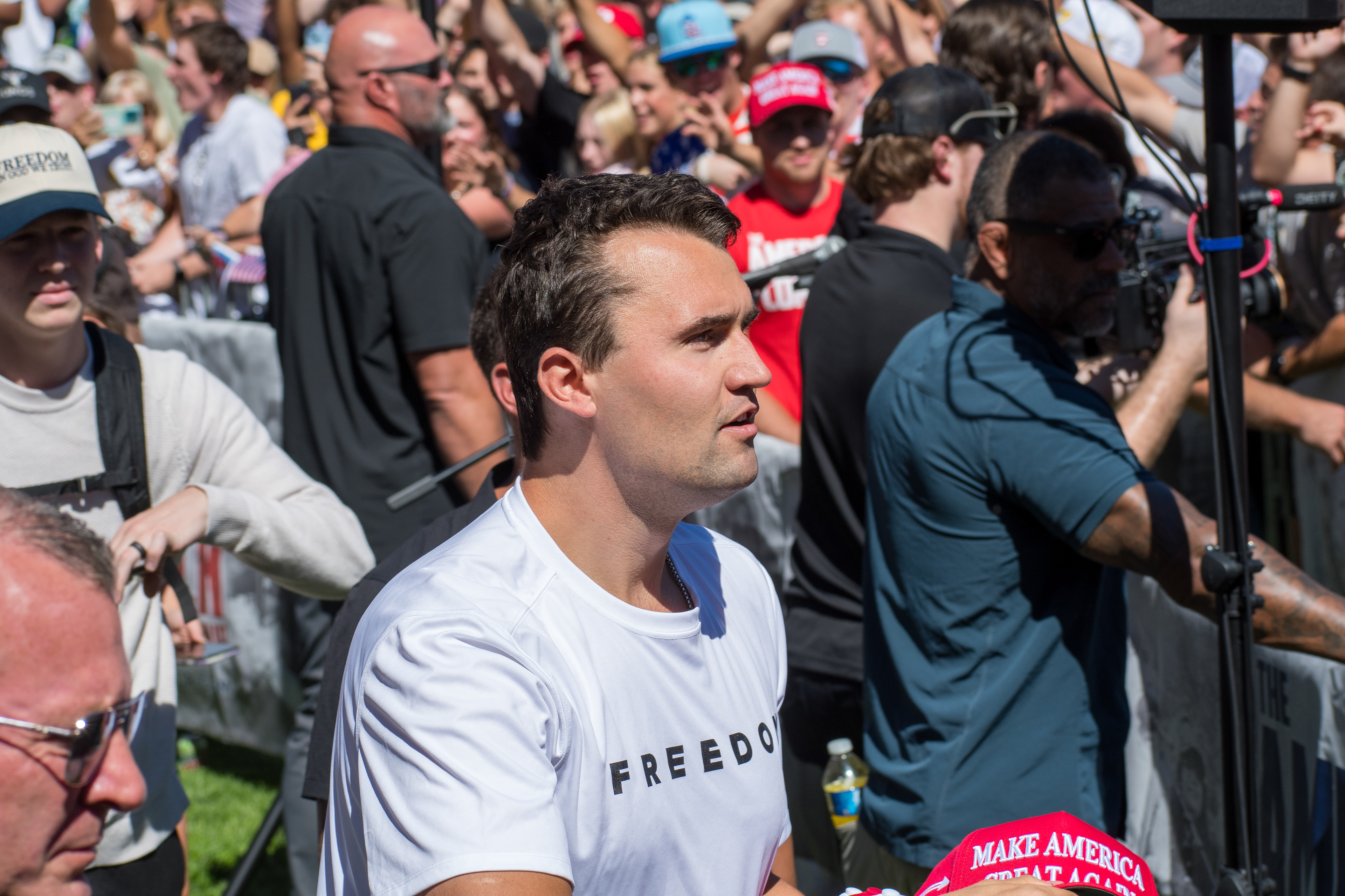  OREM, UTAH – SEPTEMBER 10, 2025: Charlie Kirk holds several “Make America Great Again” hats while interacting with supporters during a public event at Utah Valley University. Positioned near a merchandise table and surrounded by attendees, Kirk engages directly with the crowd in one of his final public moments. The image reflects the branding, outreach, and political symbolism that defined the gathering. © Charles-McClintock Wilson / ZUMA Press